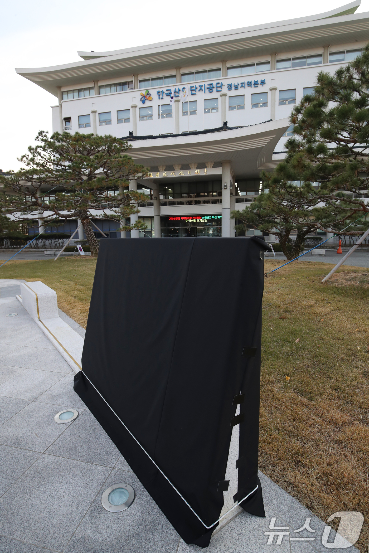 (창원=뉴스1) 윤일지 기자 = 11일 오후 경남 창원시 성산구 한국산업단지공단 경남지역본부 앞에 설치된 윤석열 대통령의 친필이 새겨진 표지석에 검은 가림막이 설치돼 있다.해당 표 …