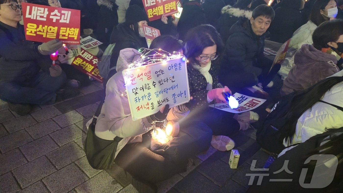  11일 저녁 대전 서구 은하수네거리 일대에서 한 시민이 윤석열 대통령의 퇴진을 촉구하며 직접 만든 피켓을 흔들고 있다. 2024.12.11 /뉴스1 ⓒ News1 허진실 기자 