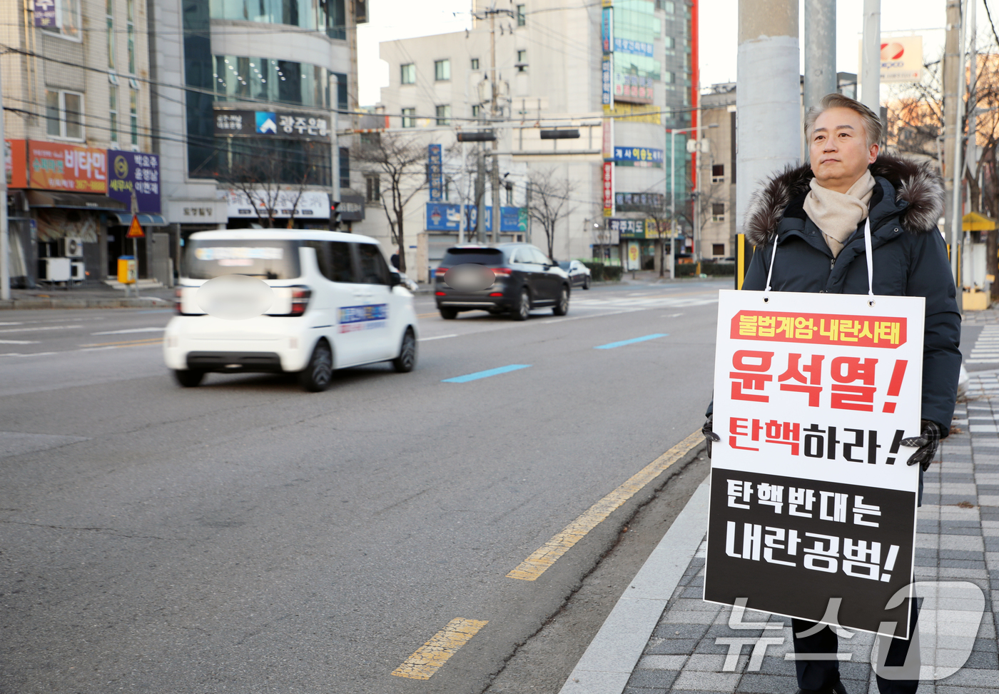 (광주=뉴스1) 이수민 기자 = 김이강 광주 서구청장이 12일 오전 광주 서구 농성동 한전서광주앞 사거리에서 '불법계엄·내란사태 윤석열 대통령 탄핵'을 요구 1인 시위를 하고 있다 …