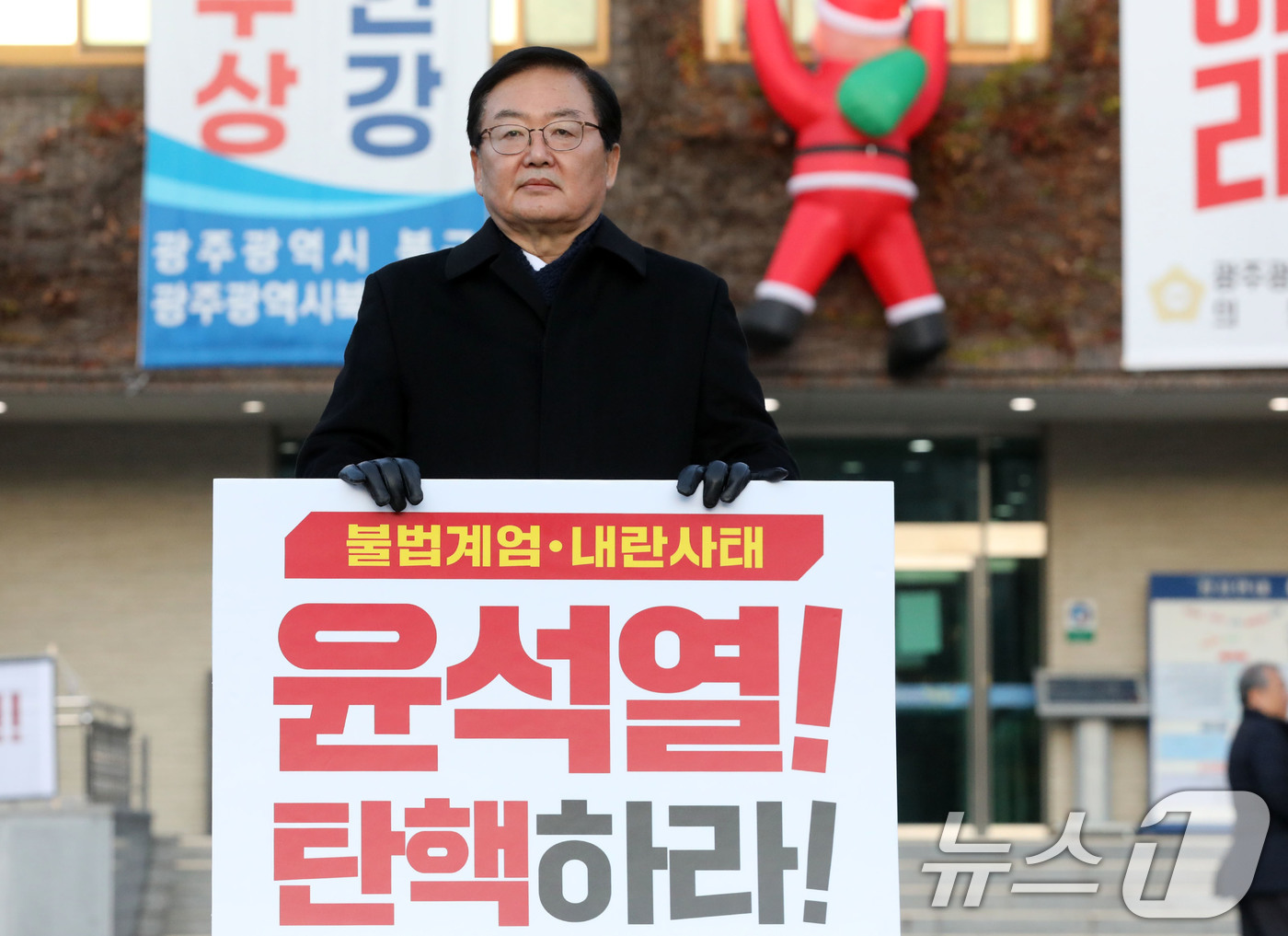 (광주=뉴스1) 박지현 기자 = 문인 광주 북구청장이 12일 오전 광주 북구청 앞에서 윤석열 대통령 탄핵 촉구 1인 피켓 시위를 하고 있다. 2024.12.12/뉴스1