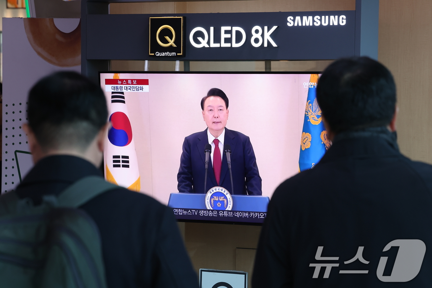 (서울=뉴스1) 김성진 기자 = 윤석열 대통령에 대한 국회의 탄핵소추안 발의일인 12일 서울 중구 서울역 대합실에서 시민들이 윤석열 대통령의 4번째 대국민 담화를 시청하고 있다. …