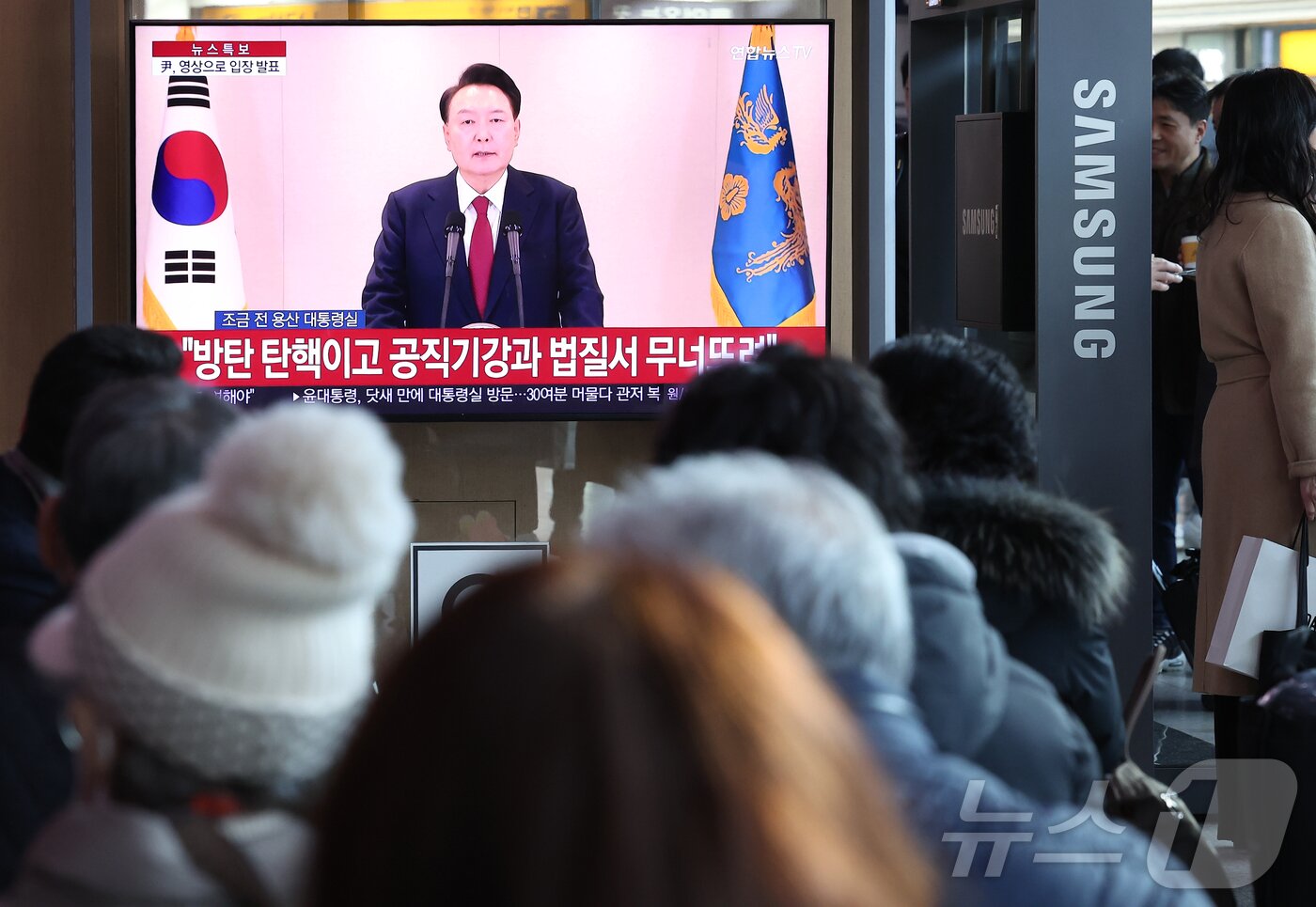 본문 이미지 - 윤석열 대통령에 대한 국회의 탄핵소추안 발의일인 12일 서울 중구 서울역 대합실에서 시민들이 윤석열 대통령의 4번째 대국민 담화를 시청하고 있다. 2024.12.12/뉴스1 ⓒ News1 김성진 기자