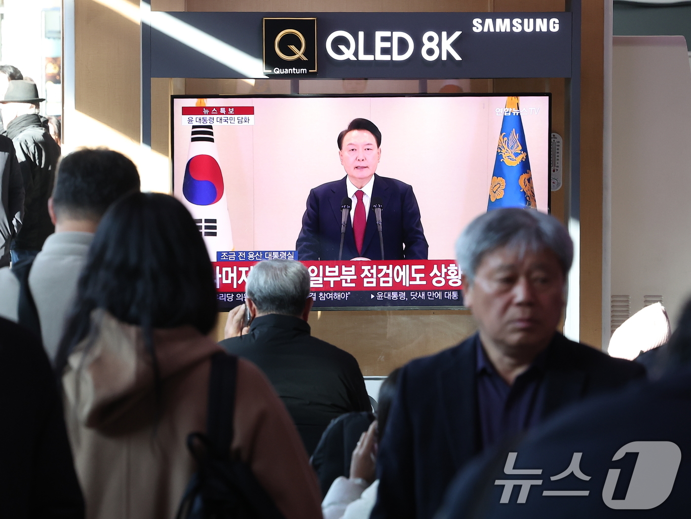 (서울=뉴스1) 김성진 기자 = 윤석열 대통령에 대한 국회의 탄핵소추안 발의일인 12일 서울 중구 서울역 대합실에서 시민들이 윤석열 대통령의 4번째 대국민 담화를 시청하고 있다. …