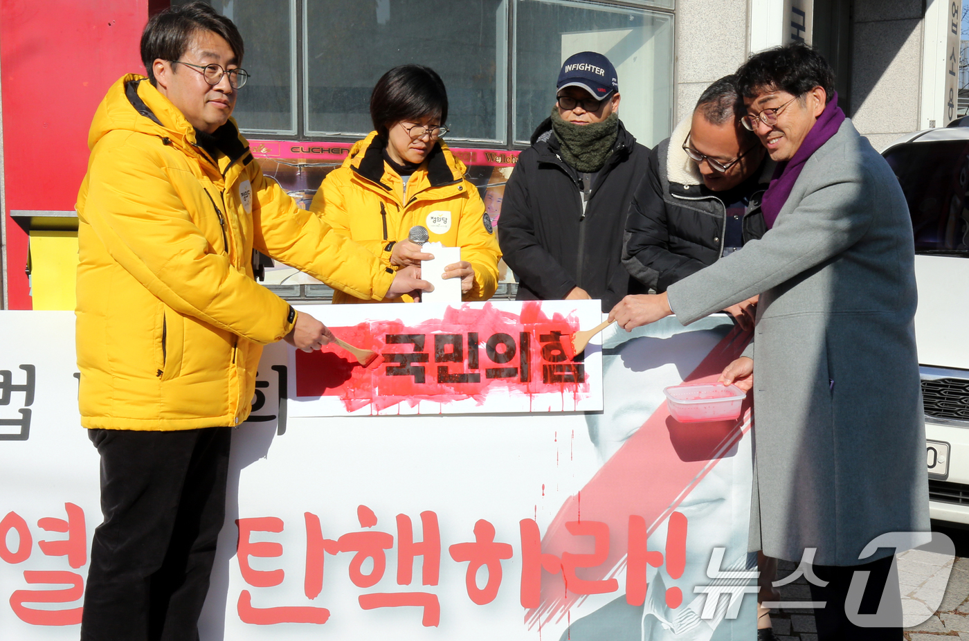 (대전=뉴스1) 김기태 기자 = 정의당 대전시당 당원들이 12일 국민의힘 대전시당 앞에서 기자회견을 열고 윤석열 대통령 탄핵을 촉구하며 국민의힘에 붉은색 페인트를 칠하는 퍼포먼스를 …