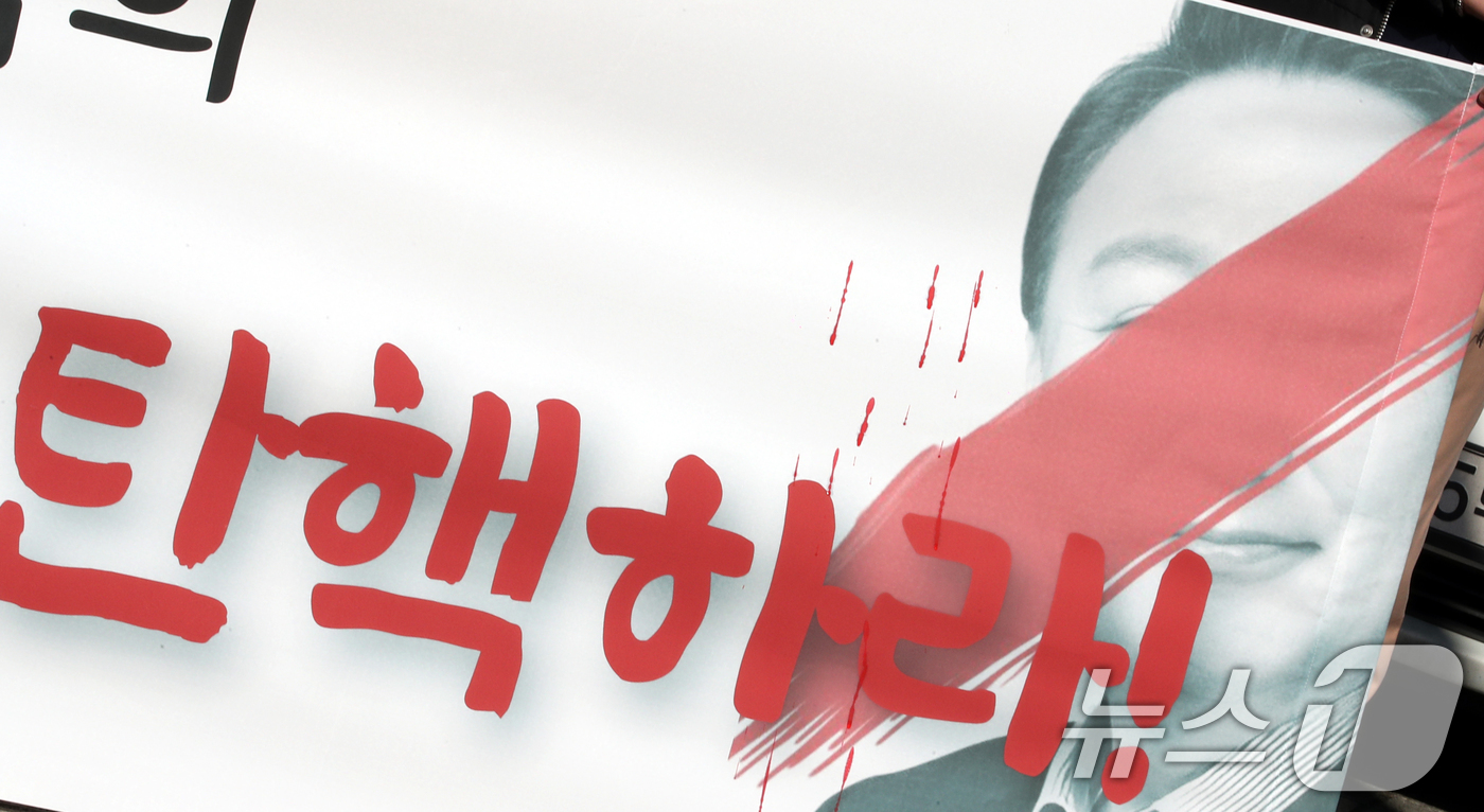(대전=뉴스1) 김기태 기자 = 정의당 대전시당 당원들이 12일 국민의힘 대전시당 앞에서 기자회견을 열고 윤석열 대통령 탄핵을 촉구했다. 윤석열 대통령 사진에 붉은색으로 칠해있다. …