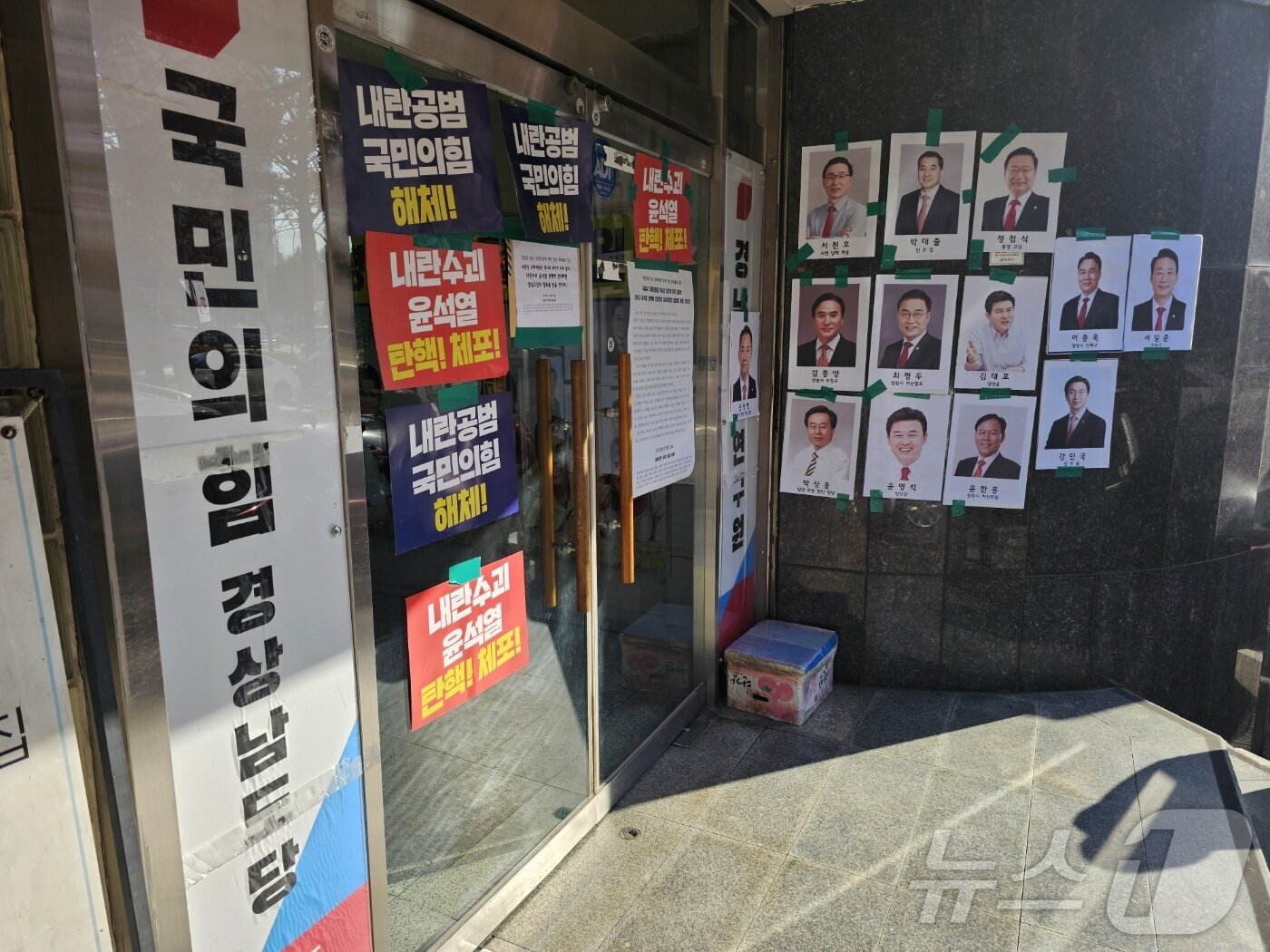 본문 이미지 - 12일 국민의힘 경남도당 당사 앞에 도내 여당 의원들의 사진과 탄핵 요구 손피켓 등이 붙여져 있다. 2024.12.12 ⓒ 뉴스1 박민석 기자