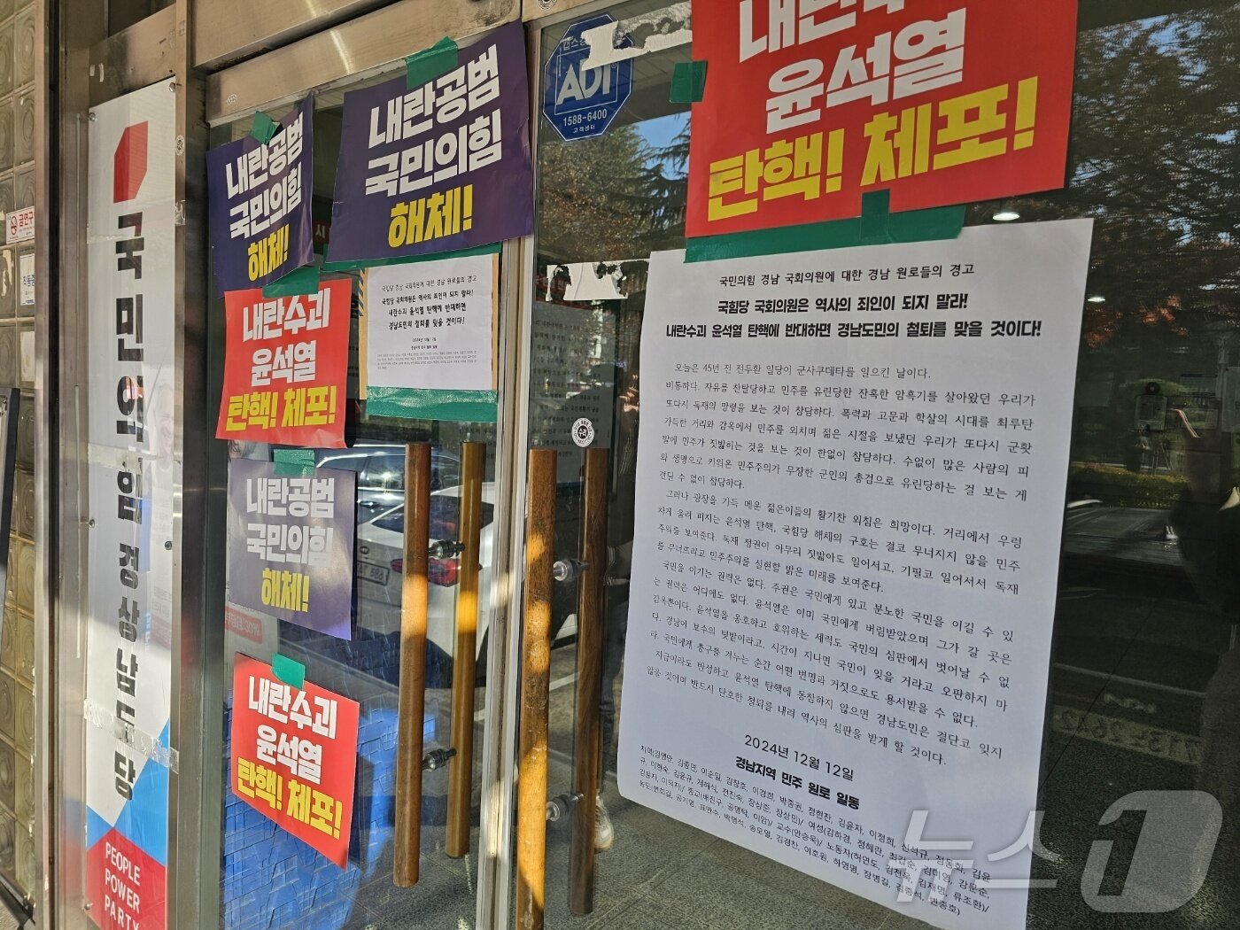 본문 이미지 - 12일 국민의힘 경남도당 당사를 찾은 경남 시민사회 등 각계 원로 44인이 대통령 탄핵 손피켓과 항의 서한을 당사 출입문에 붙였다. 2024.12.12 ⓒ 뉴스1 박민석 기자