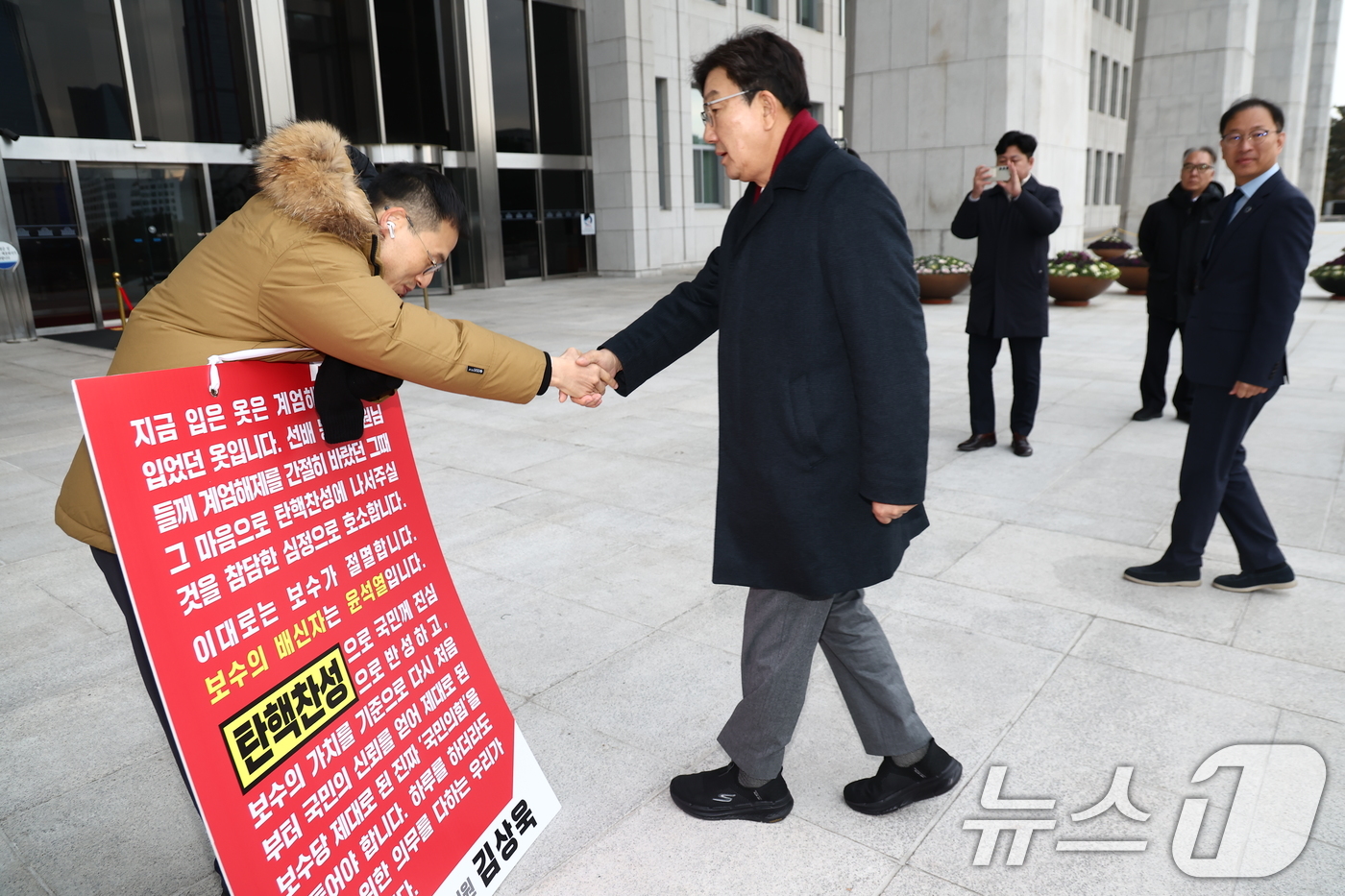 (서울=뉴스1) 김민지 기자 = 김상욱 국민의힘 의원이 13일 오전 서울 여의도 국회 본청 앞에서 윤석열 대통령 탄핵 찬성 호소 1인 시위 중 만난 권성동 원내대표와 인사하고 있다 …