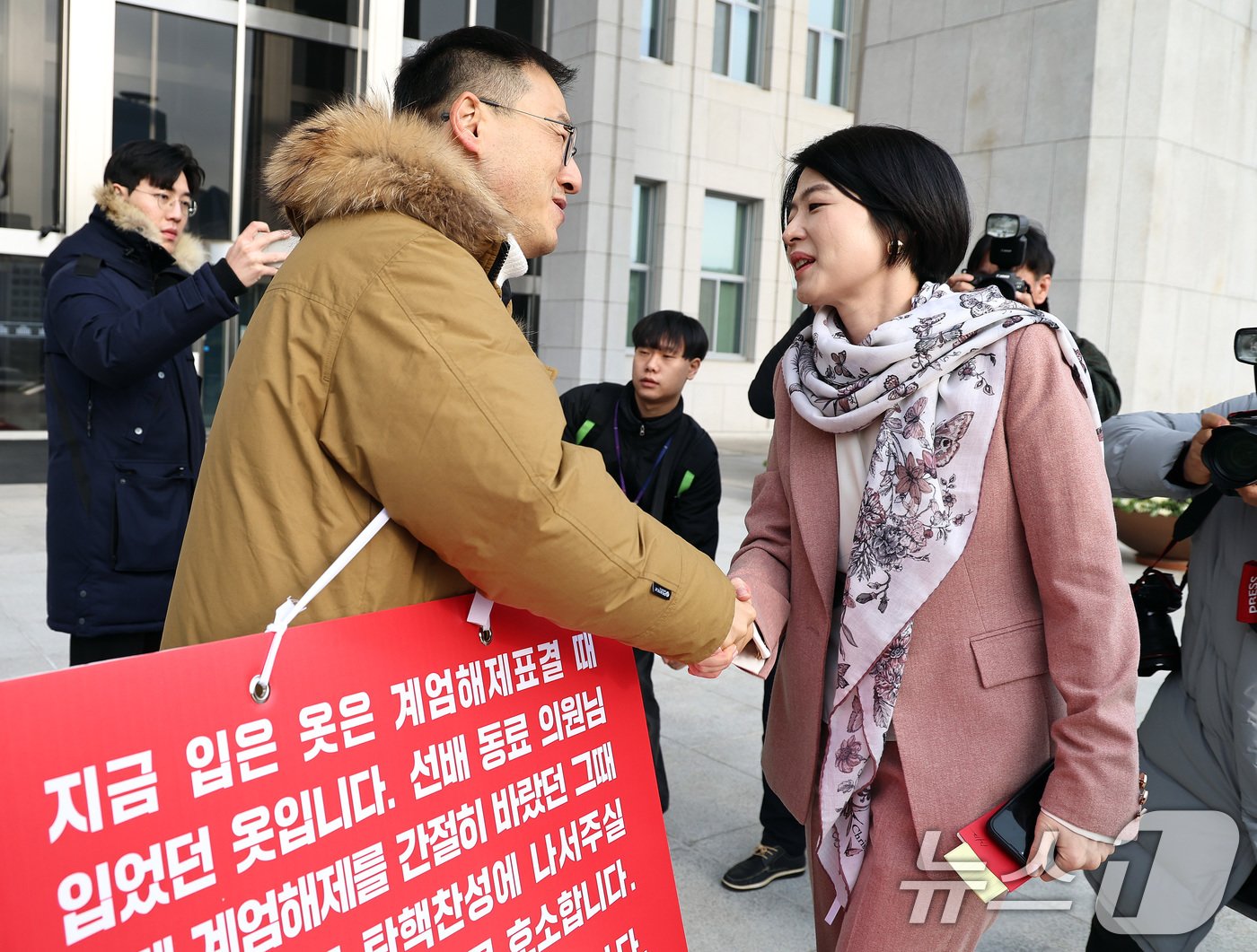 김상욱 국민의힘 의원이 13일 오전 서울 여의도 국회 본청 앞에서 윤석열 대통령 탄핵 표결 찬성을 호소하던 중 한지아 국민의힘 의원과 인사 나누고 있다. 2024.12.13/뉴스1 ⓒ News1 구윤성 기자