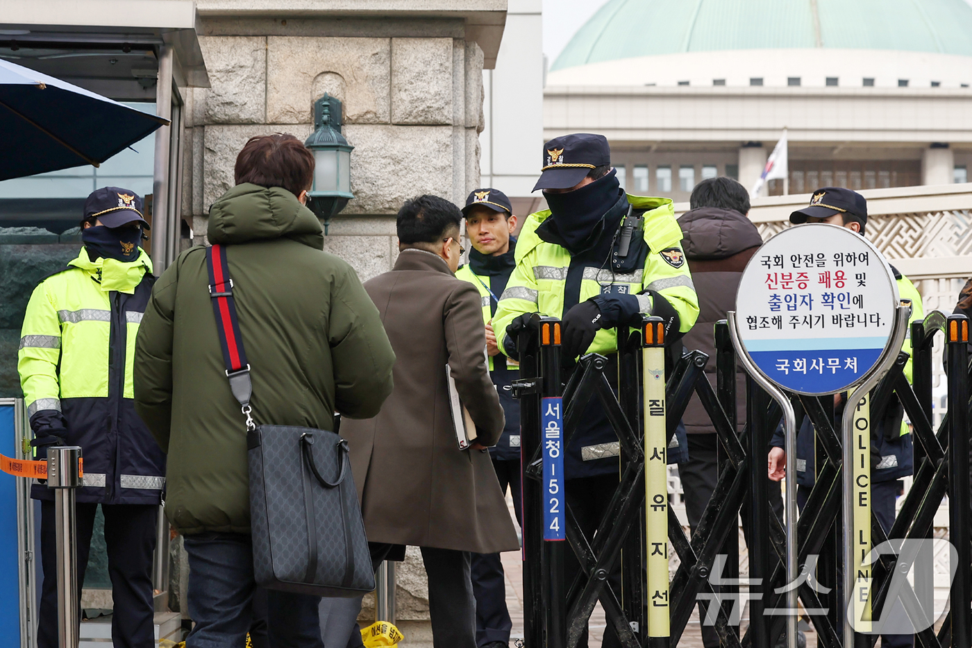 (서울=뉴스1) 민경석 기자 = 13일 서울 영등포구 여의도 국회의사당 앞에서 경찰이 방문자들에게 출입증을 확인하고 있다.국회가 윤석열 대통령 탄핵소추안이 국회에 보고되는 이날부터 …