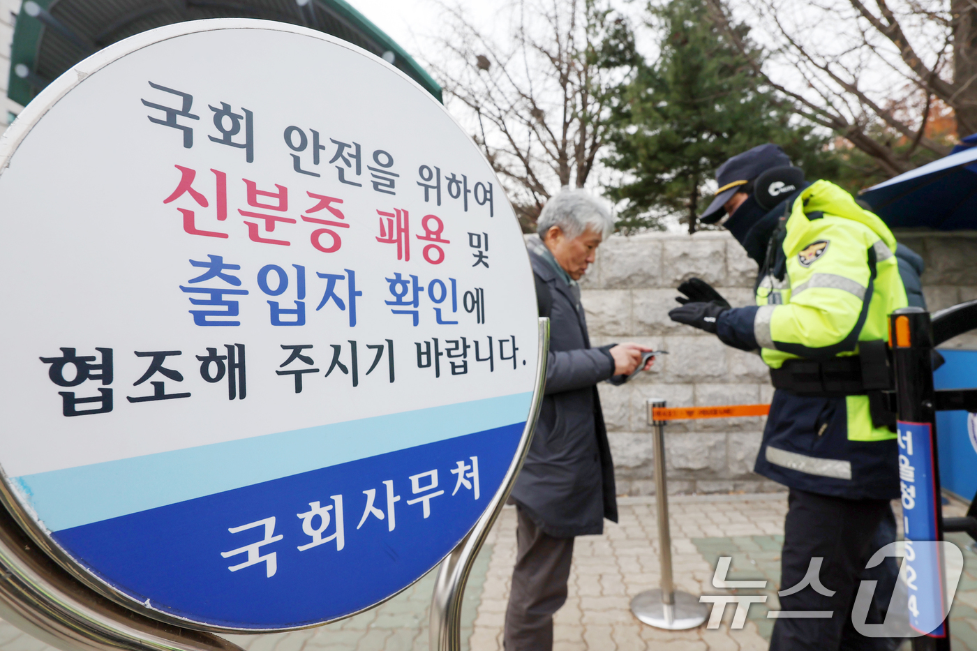 (서울=뉴스1) 민경석 기자 = 13일 서울 영등포구 여의도 국회의사당 앞에서 경찰이 방문자들에게 출입증을 확인하고 있다.국회가 윤석열 대통령 탄핵소추안이 국회에 보고되는 이날부터 …