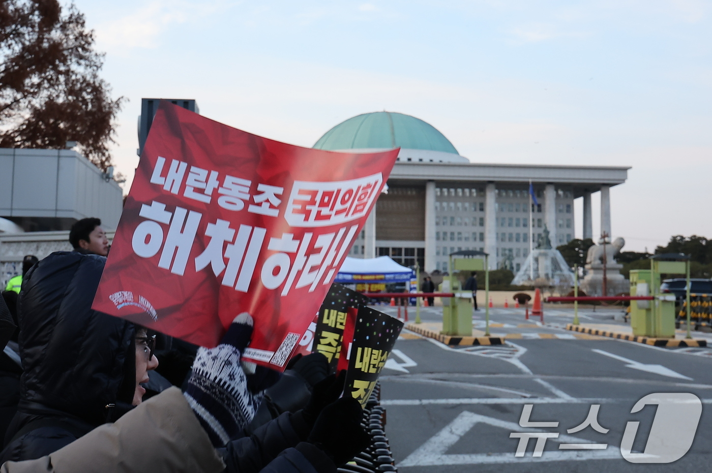 (서울=뉴스1) 김진환 기자 = 윤석열 대통령에 대한 국회의 2차 탄핵소추안 표결을 하루 앞둔 13일 오후 서울 영등포구 여의도 국회 앞에서 시민들이 국민의힘 해체를 촉구하는 손팻 …