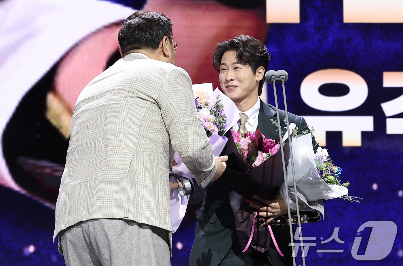 본문 이미지 - KIA 타이거즈 박찬호가 13일 서울 강남구 코엑스 오디토리움에서 열린 ‘2024 신한은행 SOL KBO 골든글러브 시상식’에서 유격수 부문 골든글러브를 수상한 후 심재학 단장에게 꽃다발을 받고 있다. 2024.12.13/뉴스1 ⓒ News1 김성진 기자