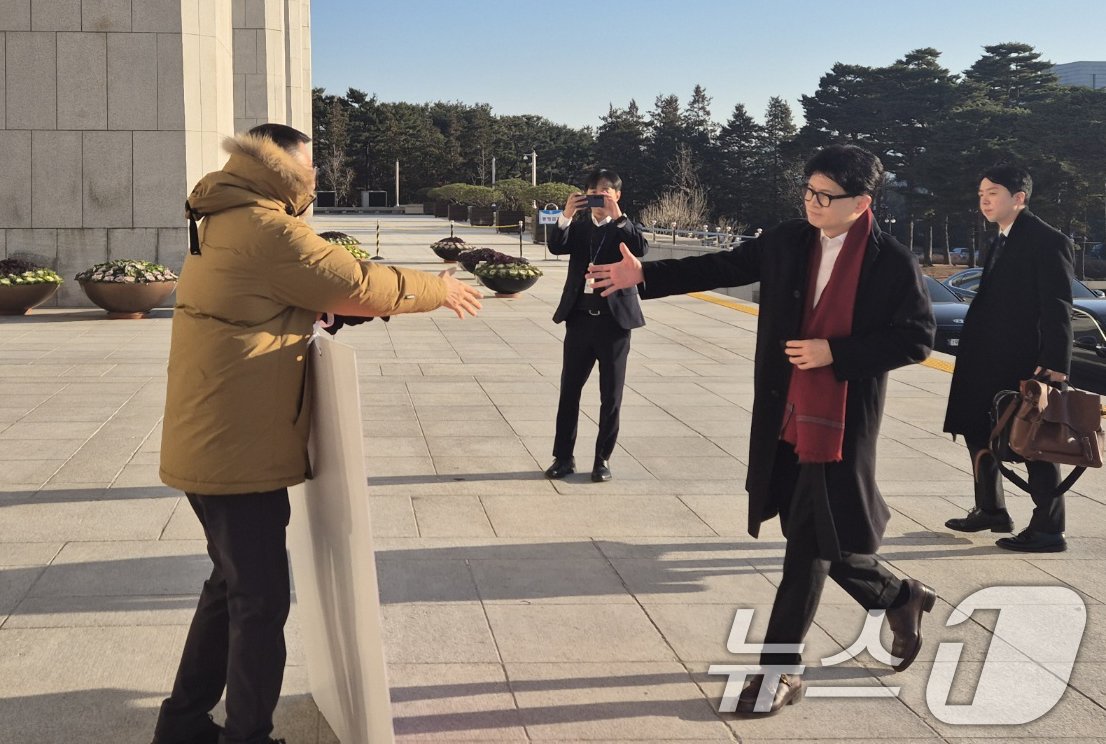 본문 이미지 - 한동훈 국민의힘 대표가 14일 오전 서울 여의도 국회에서 출근하며 윤석열 대통령 탄핵 표결 찬성 1인 시위 중인 김상욱 의원과 악수하고 있다. (김상욱 의원실 제공) 2024.12.14/뉴스1