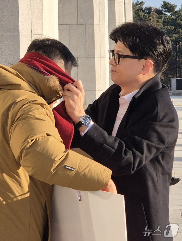 (서울=뉴스1) = 한동훈 국민의힘 대표가 14일 오전 서울 여의도 국회에서 출근하며 윤석열 대통령 탄핵 표결 찬성 1인 시위 중인 김상욱 의원에게 목도리를 둘러주고 있다. (김상 …