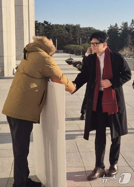 본문 이미지 - 한동훈 국민의힘 대표가 14일 오전 서울 여의도 국회에서 출근하며 윤석열 대통령 탄핵 표결 찬성 1인 시위 중인 김상욱 의원과 악수하고 있다. (김상욱 의원실 제공) 2024.12.14/뉴스1