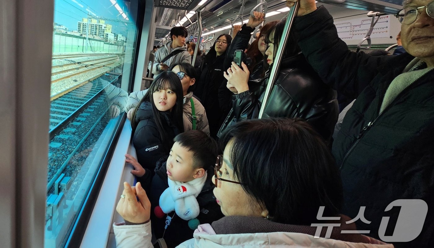 본문 이미지 - 대구권 광역철도&#40;대경선&#41; 개통 첫 날인 14일 경북 구미역에서 탑승한 한 가족이 사곡역을 지나며 경치를 감상하고 있다. 2024.12.14/뉴스1 ⓒ News1 정우용 기자