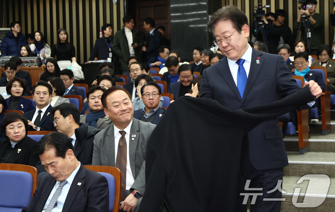 (서울=뉴스1) 김민지 기자 = 이재명 더불어민주당 대표가 14일 오후 서울 여의도 국회에서 열린 의원총회에 참석하며 외투를 벗고 있다. 2024.12.14/뉴스1