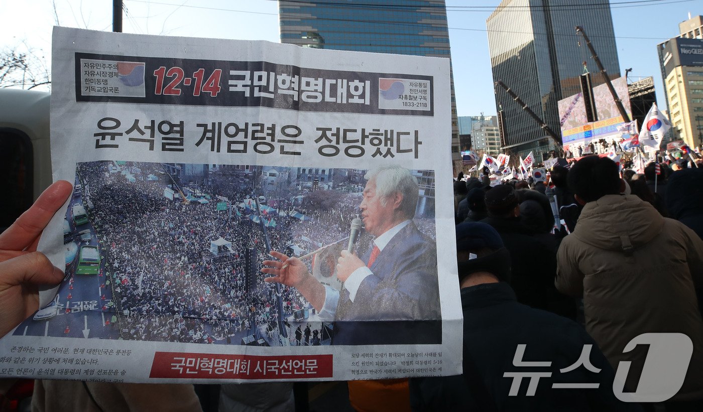 윤석열 대통령에 대한 국회 탄핵소추안 표결일인 14일 서울 세종대로 일대에서 대한민국살리기국민운동본부를 비롯한 보수단체 회원들이 ‘윤석열 계엄령은 정당했다’ 문구가 적힌 전단지를 들고 12·14 광화문 국민혁명대회에 참석하고 있다. 2024.12.14/뉴스1 ⓒ News1 박세연 기자