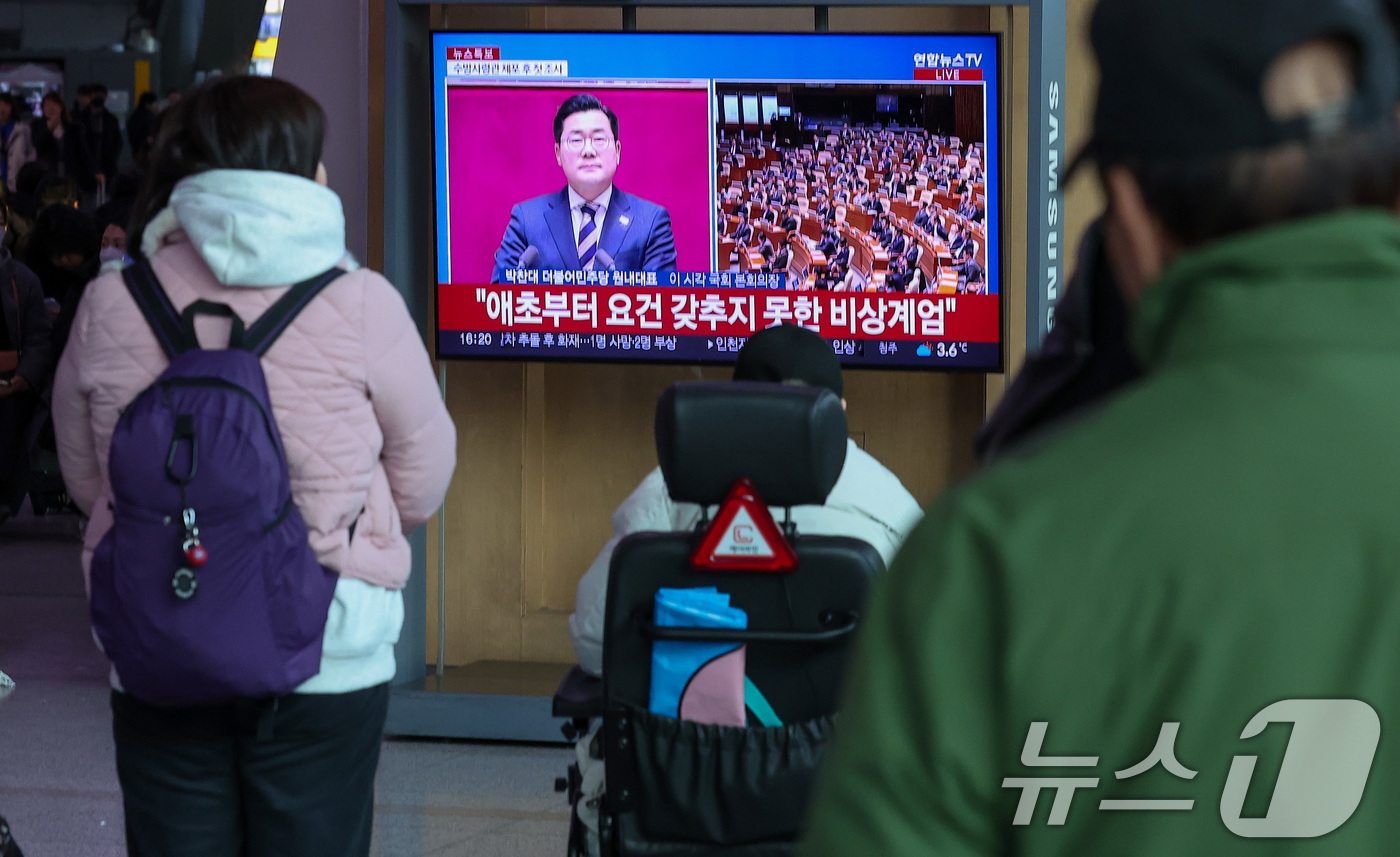 (서울=뉴스1) 김성진 기자 = 윤석열 대통령에 대한 탄핵소추안 표결이 예정된 14일 서울 용산구 서울역 대합실에서 시민들이 뉴스 속보를 시청하고 있다. 2024.12.14/뉴스1 …