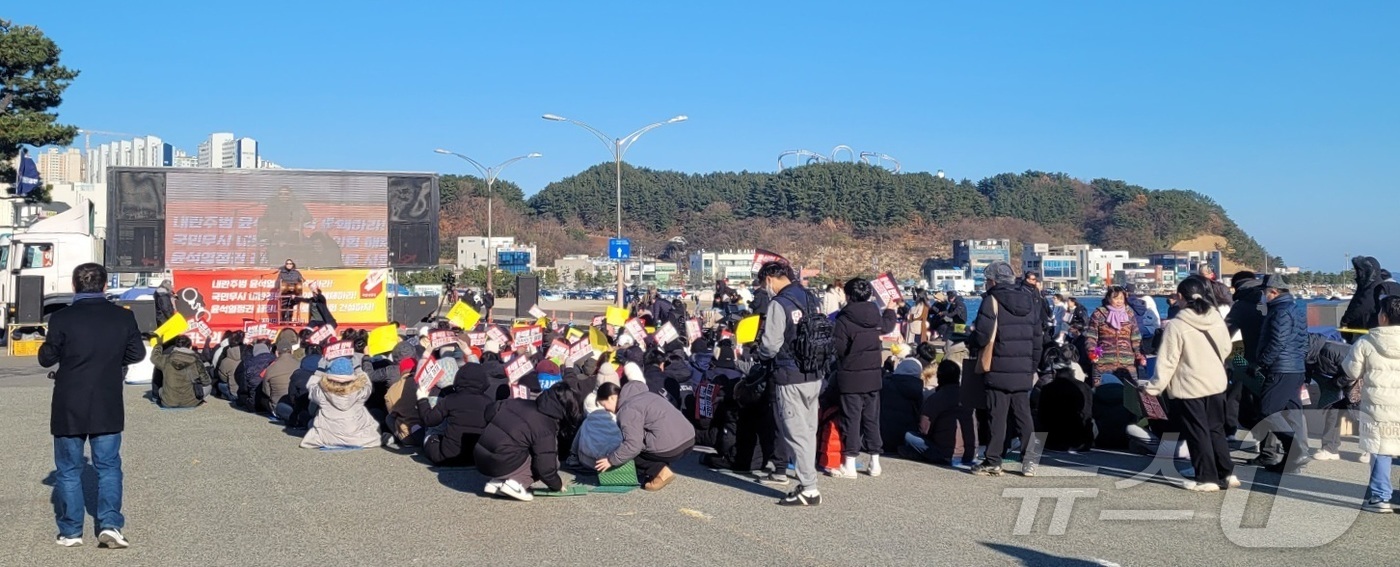 (포항=뉴스1) 최창호 기자 = 윤석열 대통령 탄핵소추안 2차 표결을 앞둔 14일 오후 경북 포항시 북구 영일대해수욕장 광장에 모인 시민들이 국회에서 진행  중인 투표 상황을 지켜 …