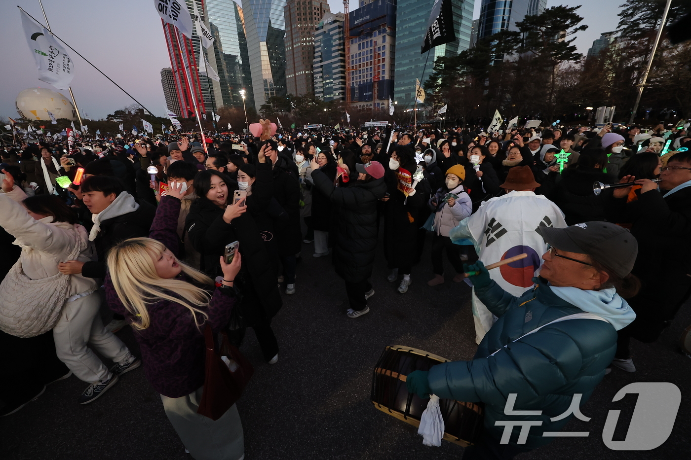 (서울=뉴스1) 김도우 기자 = 윤석열 대통령에 대한 탄핵소추안이 가결된 14일 오후 서울 여의도공원에서 윤석열 즉각 탄핵 범국민 촛불대행진에 참여한 시민들이 사물놀이를 하며 기뻐 …