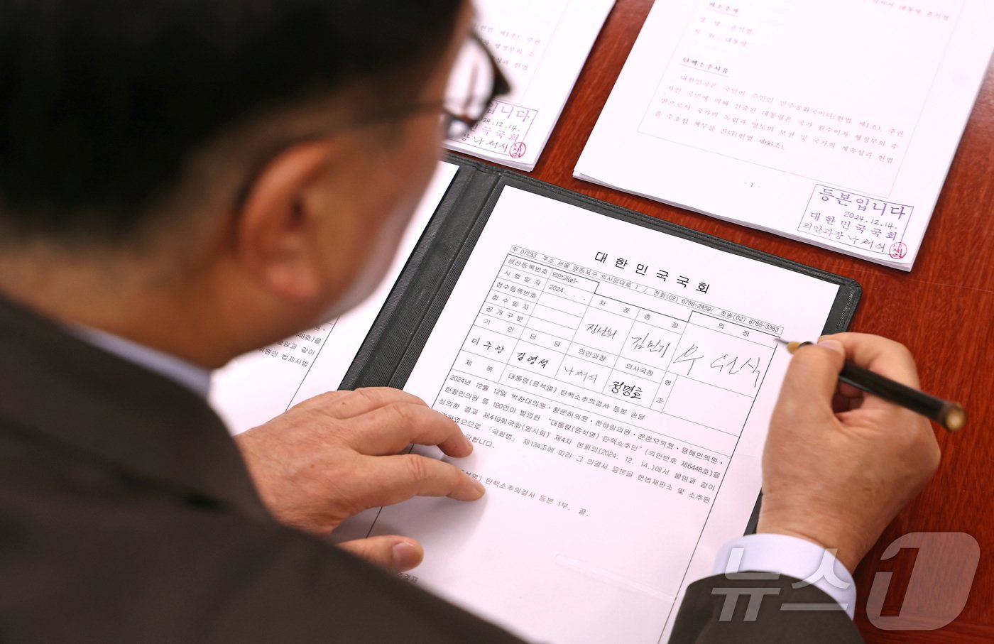 본문 이미지 - 우원식 국회의장이 윤석열 대통령 탄핵안이 가결된 14일 오후 서울 여의도 국회 의장실에서 탄핵소추의결서에 서명하고 있다. 2024.12.14/뉴스1 ⓒ News1 국회사진취재단