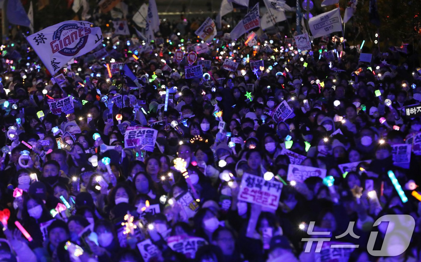 본문 이미지 - 윤석열 대통령에 대한 탄핵소추안 표결일인 14일 오후 부산 부산진구 전포대로에서 열린 '윤석열 탄핵·체포 부산시민대회'에서 참가자들이 윤 대통령의 탄핵소추안이 가결된 후 손피켓과 응원봉을 들고 있다. 2024.12.14/뉴스1 ⓒ News1 윤일지 기자