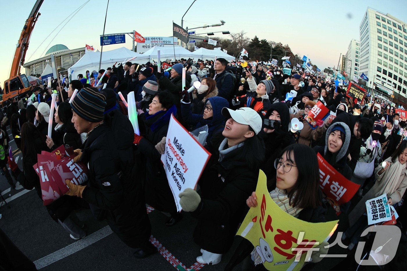 본문 이미지 - 윤석열 대통령에 대한 탄핵소추안이 가결된 14일 오후 서울 여의도 국회의사당 앞에서 열린 윤석열 즉각 탄핵 범국민 촛불대행진에 참여한 시민들이 환호하고 있다. 2024.12.14/뉴스1 ⓒ News1 박정호 기자