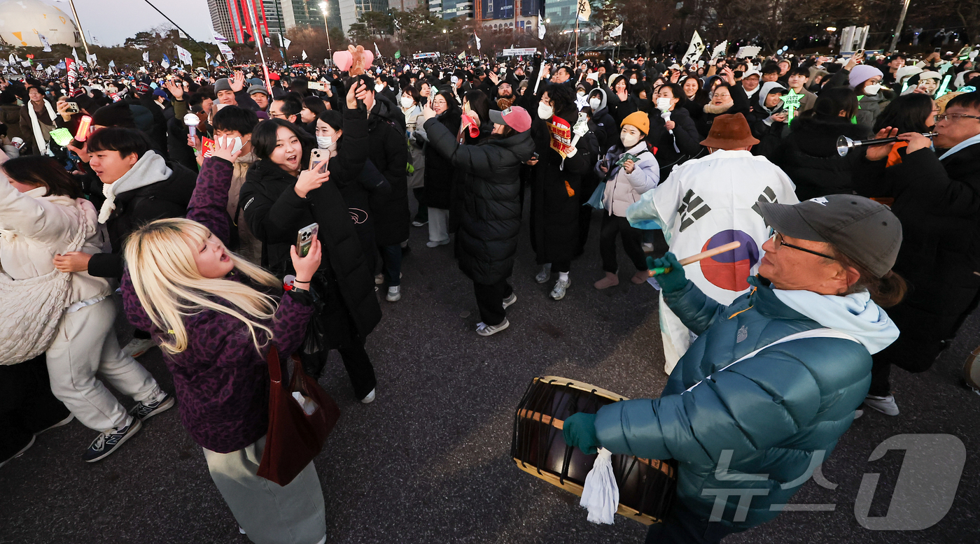 (서울=뉴스1) 김도우 기자 = 윤석열 대통령에 대한 탄핵소추안이 가결된 14일 오후 서울 여의도공원에서 윤석열 즉각 탄핵 범국민 촛불대행진에 참여한 시민들이 사물놀이를 하며 기뻐 …