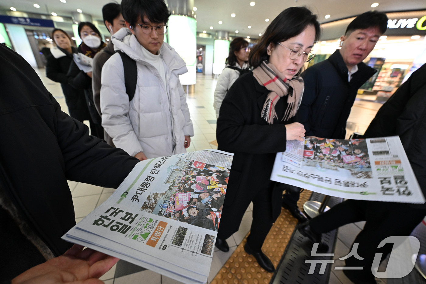 (서울=뉴스1) 박세연 기자 = 윤석열 대통령의 탄핵안이 국회에서 가결 된 14일 오후 서울역에서 관계자들이 한국일보 특별판을 시민들에게 나눠주고 있다. (한국일보 제공)2024. …