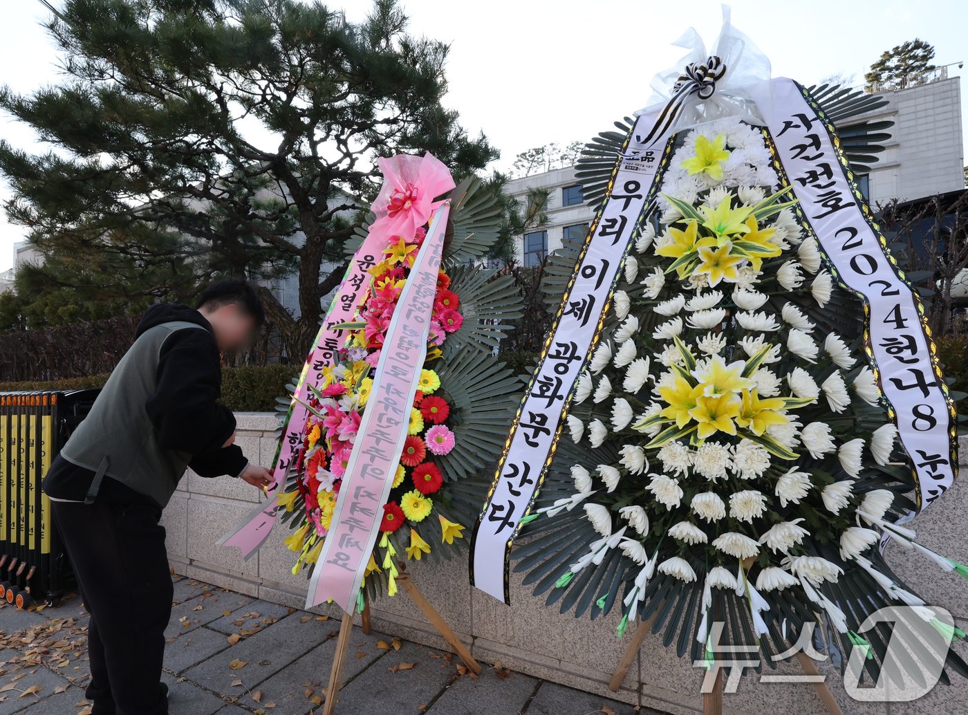 윤석열 대통령 탄핵소추안이 국회에서 가결되면서 공이 헌법재판소로 넘어왔다. 탄핵 사건이 접수되면 헌법재판소는 180일 내에 대통령 파면 여부를 결정해야 한다. 15일 서울 종로구 헌법재판소 앞에 윤석열 대통령의 응원 화환과 탄핵 촉구 화한이 나란히 놓여 있다. 2024.12.15/뉴스1 ⓒ News1 송원영 기자