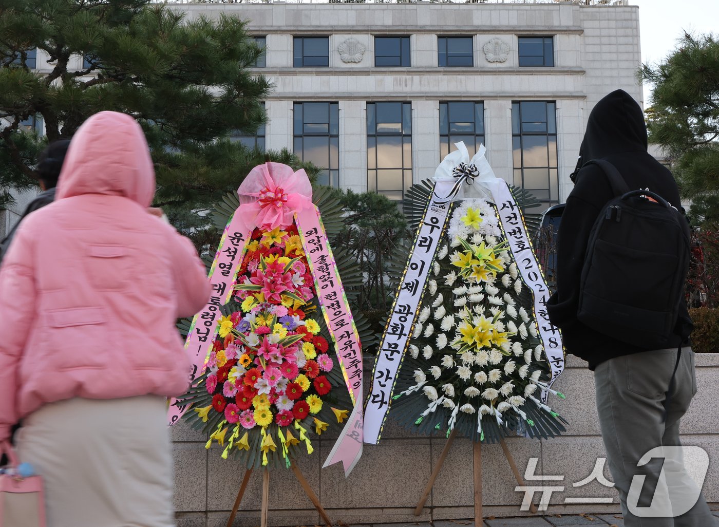 윤석열 대통령 탄핵소추안이 국회에서 가결되면서 공이 헌법재판소로 넘어왔다. 탄핵 사건이 접수되면 헌법재판소는 180일 내에 대통령 파면 여부를 결정해야 한다. 15일 서울 종로구 헌법재판소 앞에 윤석열 대통령의 응원 화환과 탄핵 촉구 화한이 나란히 놓여 있다. 2024.12.15/뉴스1 ⓒ News1 송원영 기자