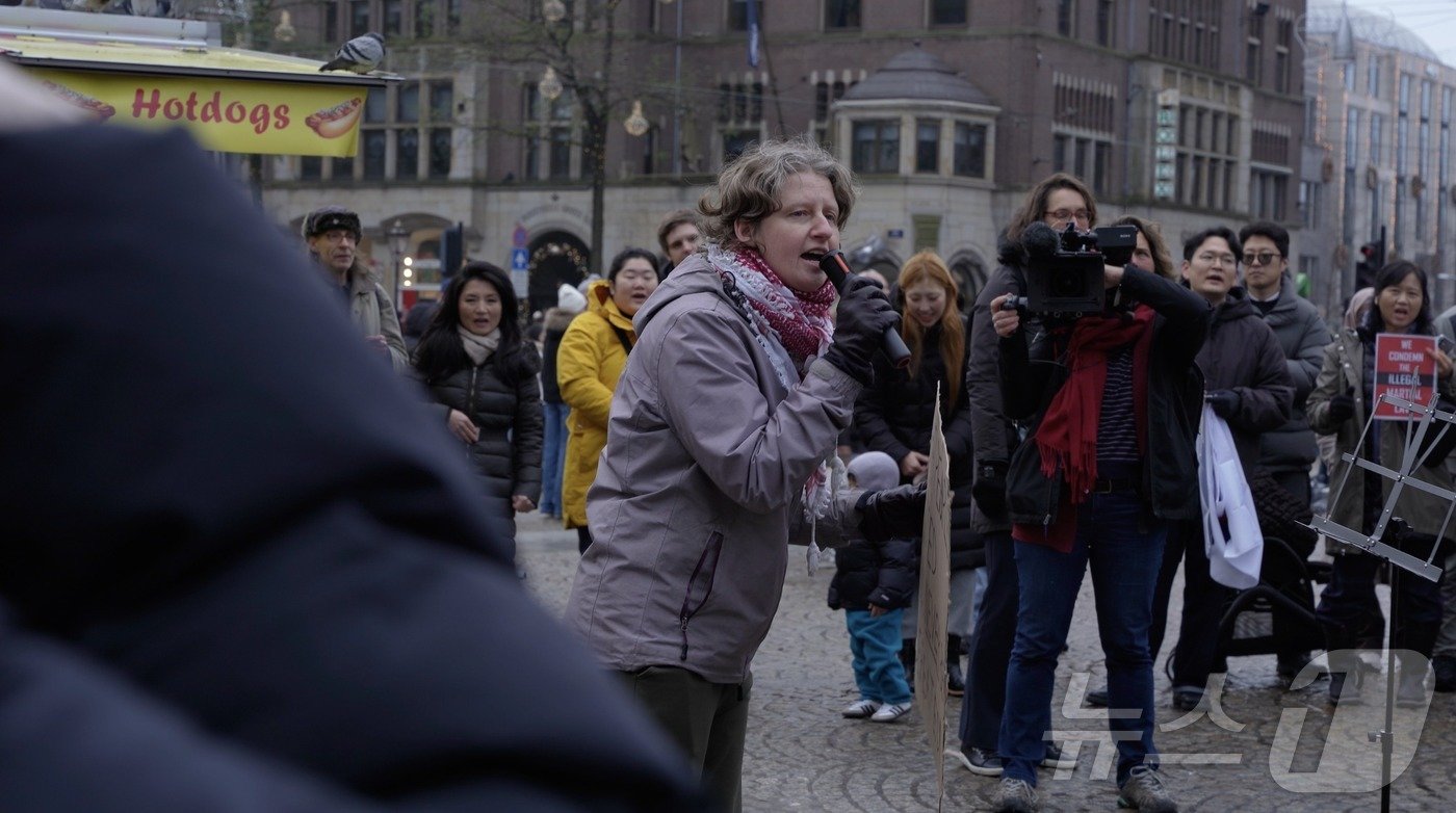 본문 이미지 - 14일&#40;현지시간&#41; 네덜란드 암스테르담 담 스퀘어에서 디아나 비텐도르프 교수가 마이크를 들고 자유발언을 하고 있다. 2024.12.14/ⓒ 뉴스1 차현정 통신원