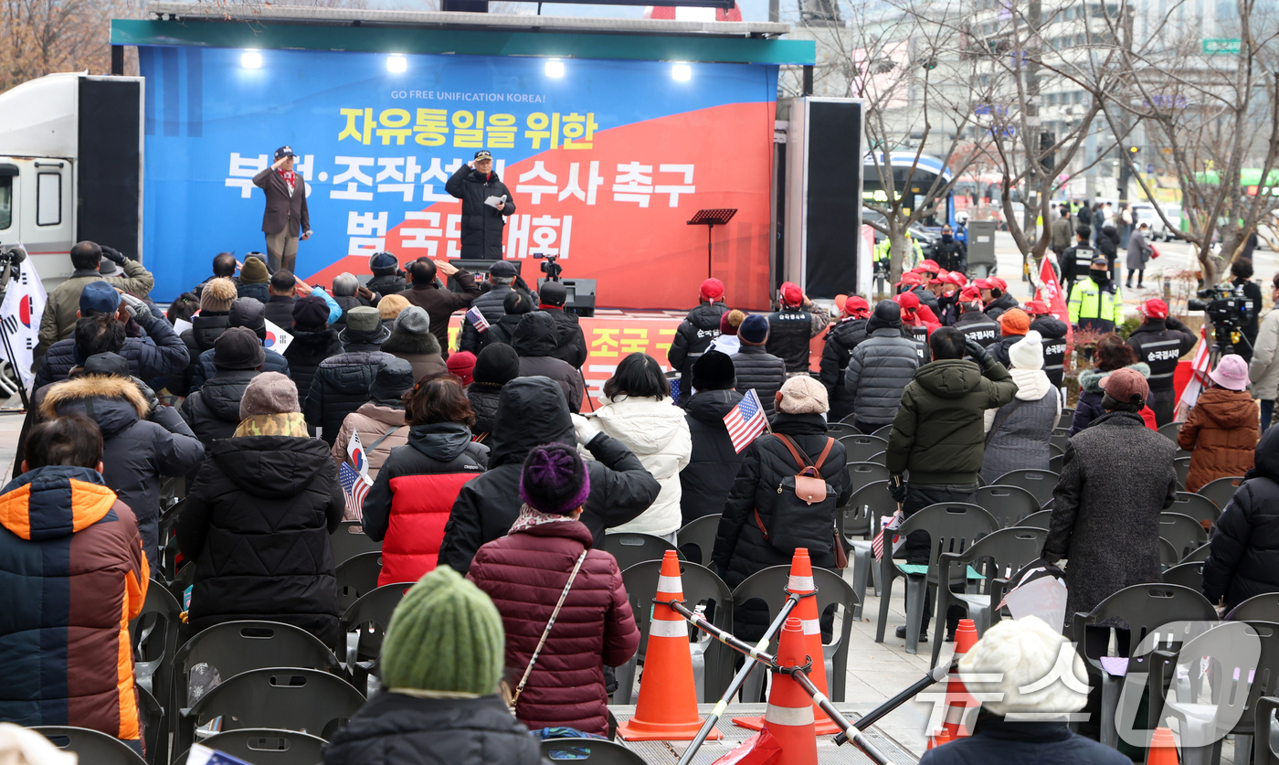 (서울=뉴스1) 김명섭 기자 = 16일 서울 중구 동화면세점 앞에서 열린 자유통일당 탄핵반대 집회에서 참가자들이 국기에 대한 경례를 하고 있다. 2024.12.16/뉴스1