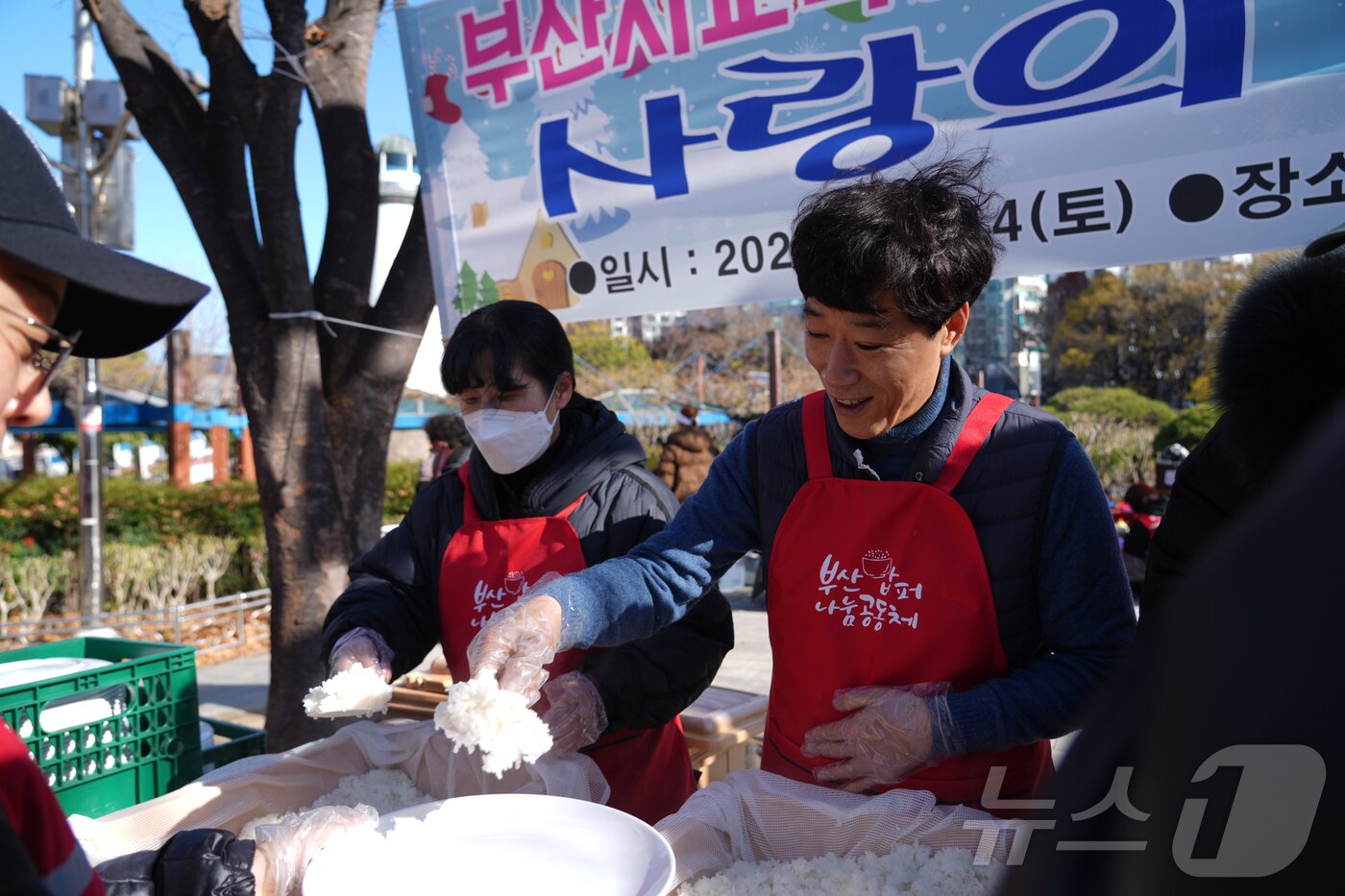 본문 이미지 - 최윤홍 부산시교육감 권한대행(오른쪽)이 14일 '사랑의 연말 한 상 나눔–독거노인 배식 봉사 활동'에 참여해 배식을 담당하고 있다.(부산시교육청 제공)