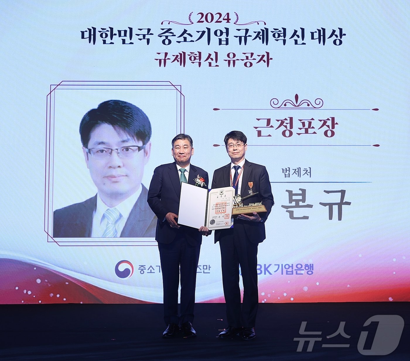 본문 이미지 - 최승재 중소기업 옴부즈만이 &#39;2024 대한민국 중소기업 규제혁신 대상&#39;에서 구본규 법제처 부이사관에게 근정포장을 수상하고 기념 촬영을 하고 있다.&#40;중소기업 옴부즈만 제공&#41;