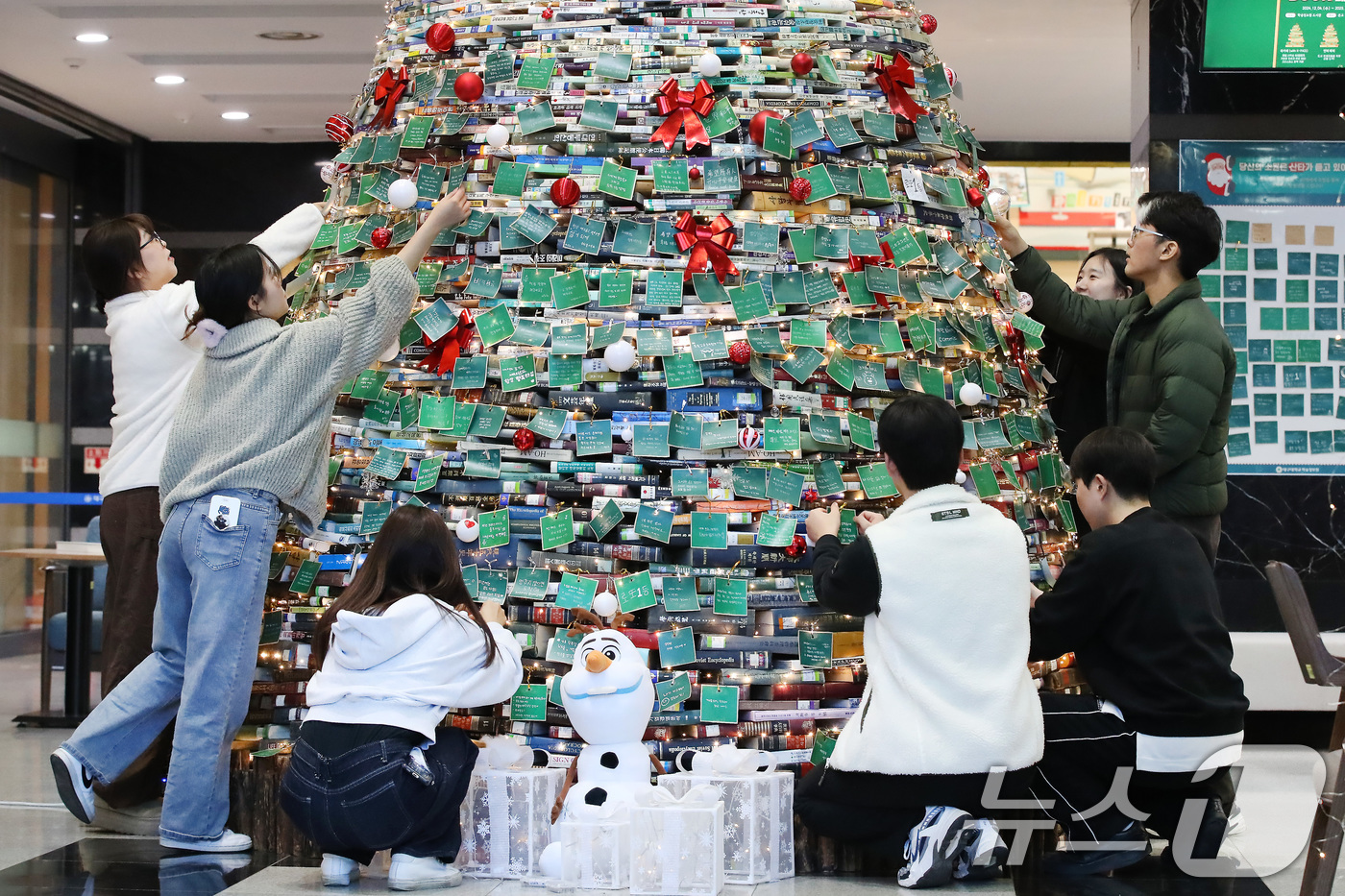 (경산=뉴스1) 공정식 기자 = 17일 대구대학교 경산캠퍼스 창파도서관 로비에서 학생들이 '크리스마스 북(Book) 트리'에 크리스마스와 새해를 앞두고 각자의 소망을 적은 소원지를 …
