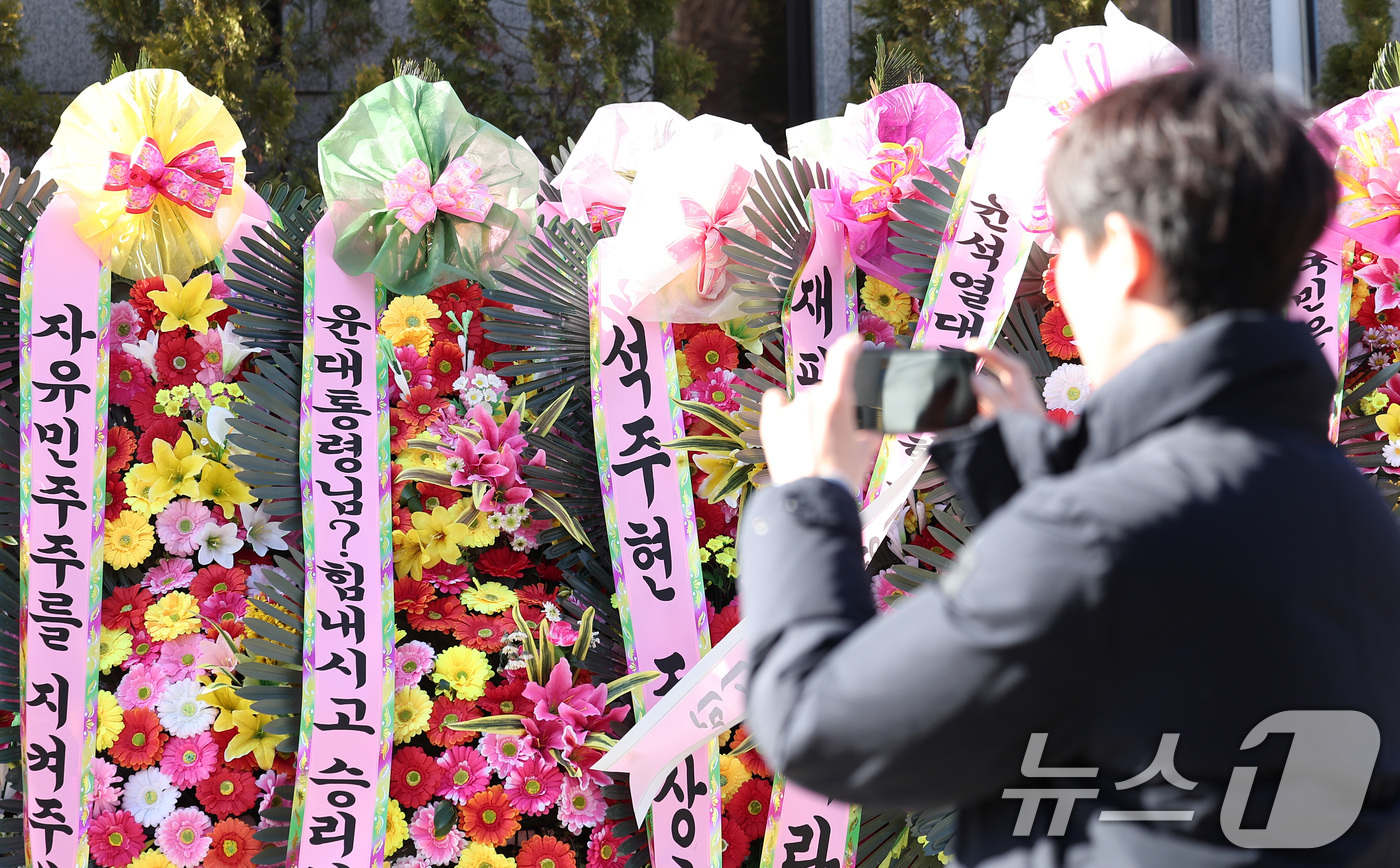 (서울=뉴스1) 김성진 기자 = 12.3 비상계엄 관련 윤석열 대통령의 탄핵심판을 앞둔 18일 서울 종로구 헌법재판소 앞에 윤석열 대통령 탄핵을 반대하는 화환이 놓여져 있다.이날 …