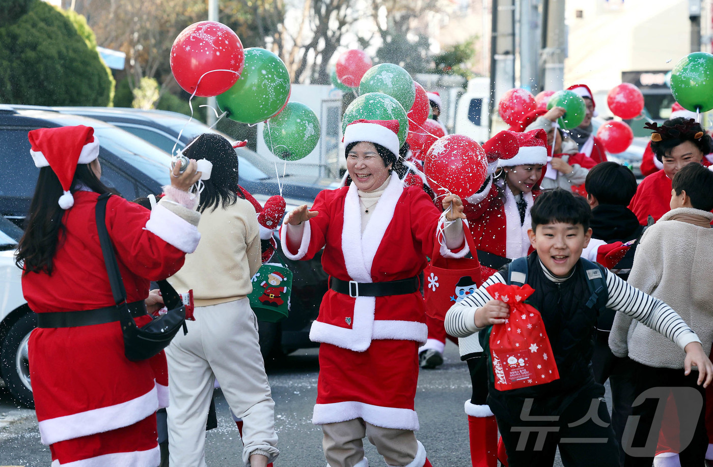 (광주=뉴스1) 박지현 기자 = 19일 광주 북구 용봉동 용주초등학교 정문 인근에서 산타복장을 하고 몰래산타로 변신한 지역사회보장협의체 회원들과 동행정복지센터 직원들이 크리스마스를 …