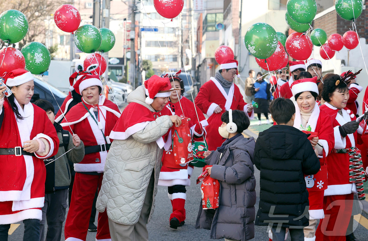 (광주=뉴스1) 박지현 기자 = 19일 광주 북구 용봉동 용주초등학교 정문 인근에서 산타복장을 하고 몰래산타로 변신한 지역사회보장협의체 회원들과 동행정복지센터 직원들이 크리스마스를 …