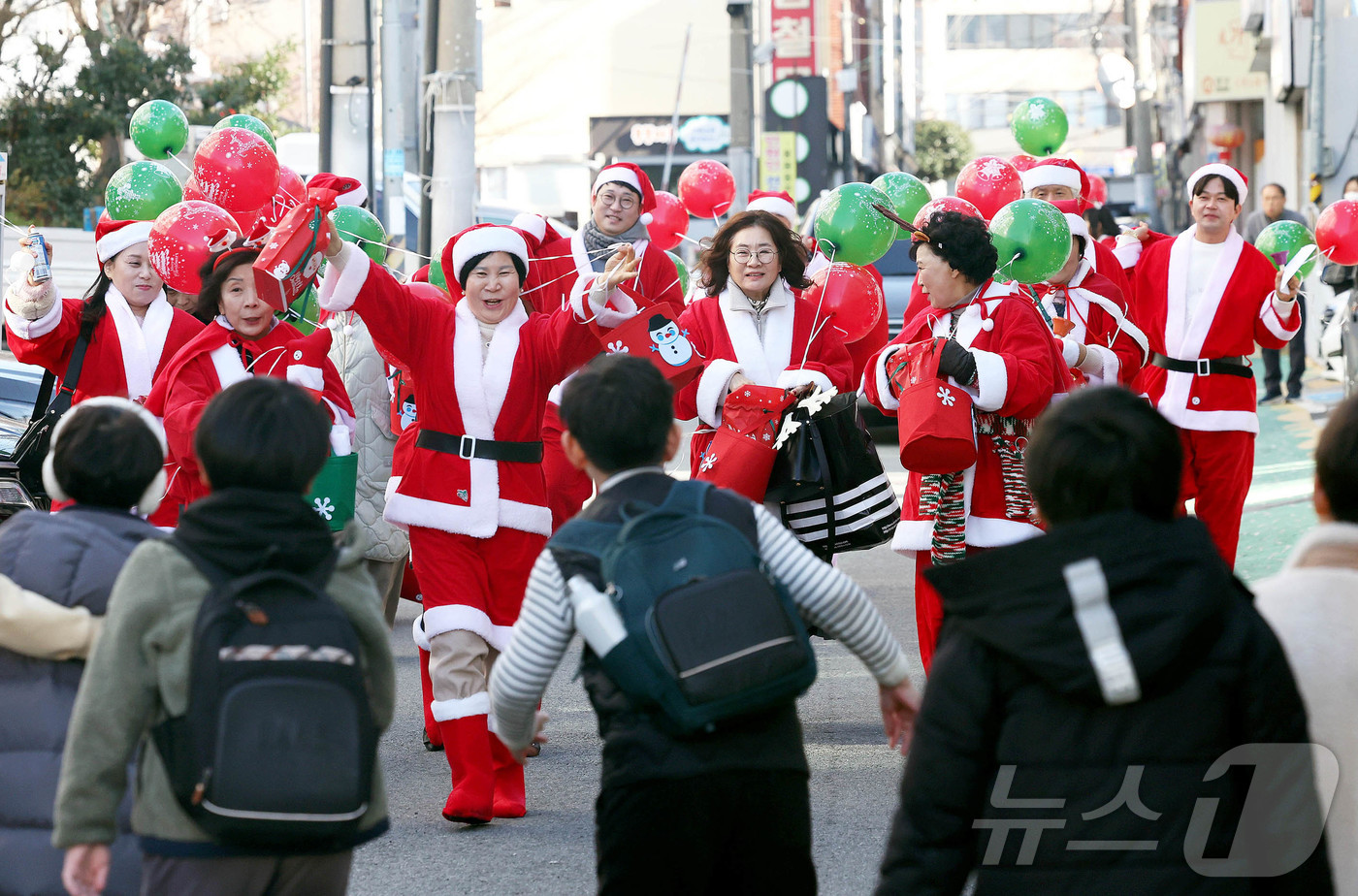 (광주=뉴스1) 박지현 기자 = 19일 광주 북구 용봉동 용주초등학교 정문 인근에서 산타복장을 하고 몰래산타로 변신한 지역사회보장협의체 회원들과 동행정복지센터 직원들이 크리스마스를 …