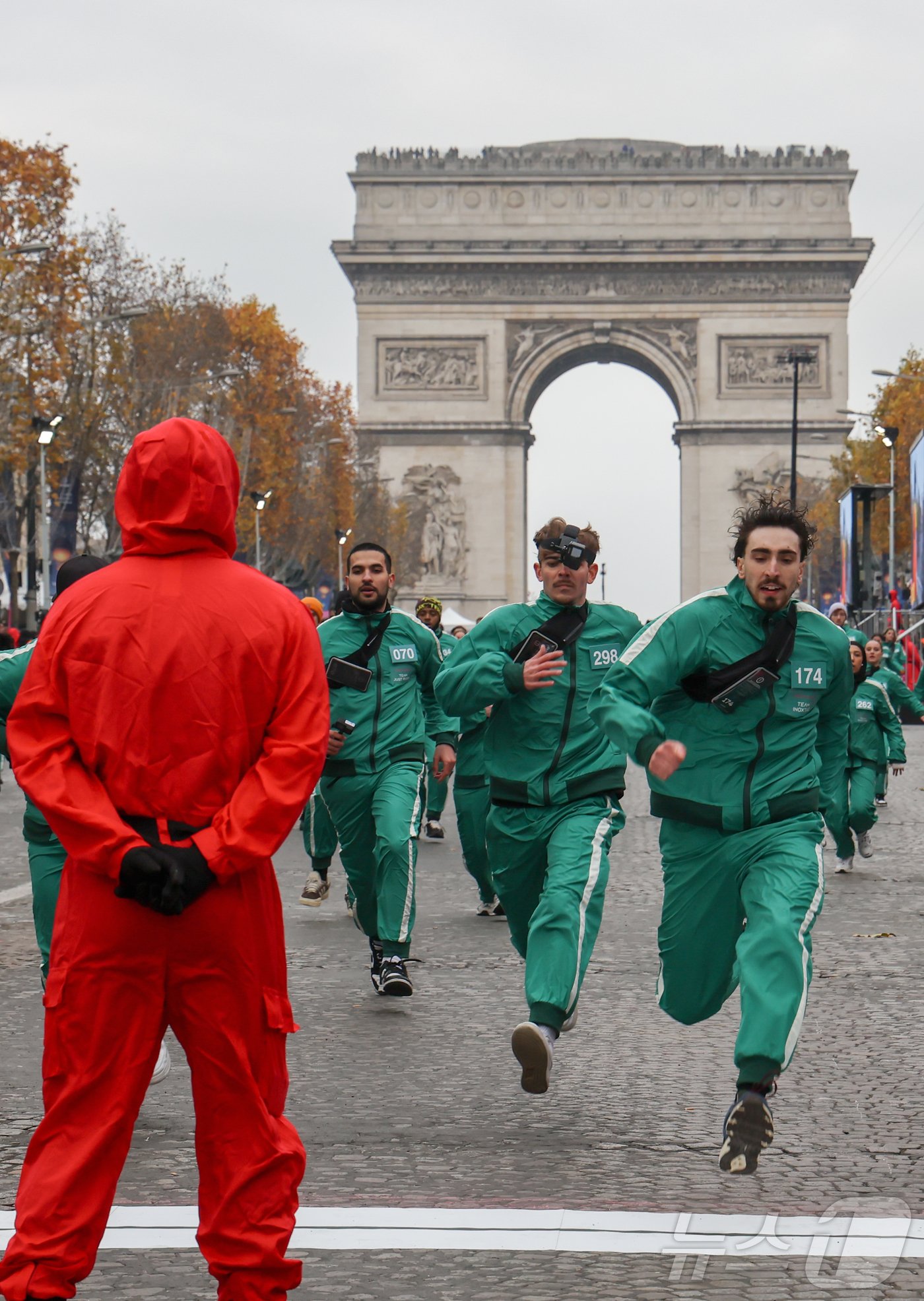 본문 이미지 - 11일(현지시간) 프랑스 파리 샹젤리제 거리에서 열린 넷플릭스 오리지널 시리즈 ‘오징어게임’ 재현 현장 이벤트에서 참가자들이 드라마 속 게임인 ‘무궁화꽃이 피었습니다’에 참여하고 있다.  2024.12.2/뉴스1 ⓒ News1 이준성 기자