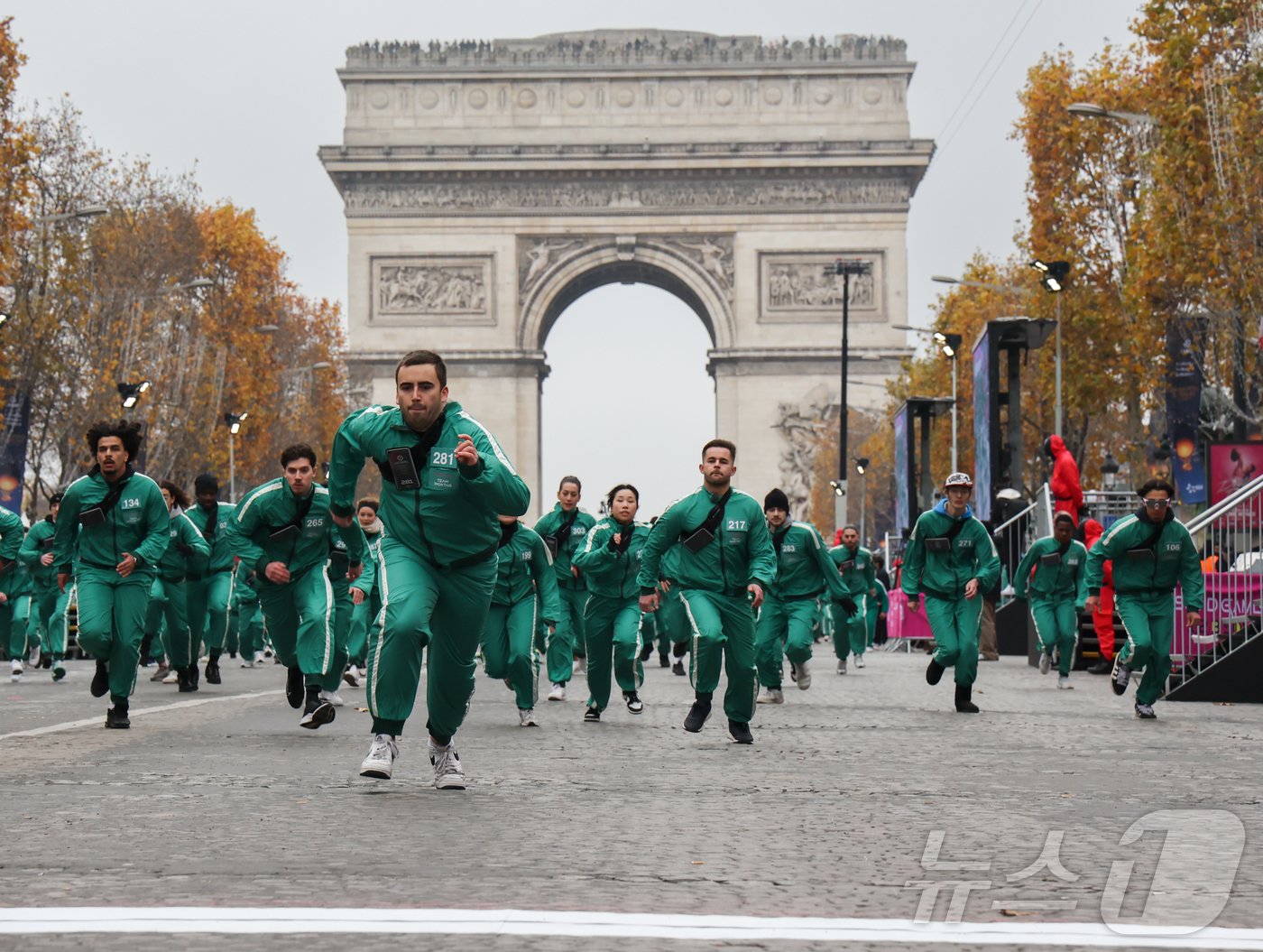 본문 이미지 - 1일(현지시간) 프랑스 파리 샹젤리제 거리에서 열린 넷플릭스 오리지널 시리즈 ‘오징어게임’ 재현 현장 이벤트에서 참가자들이 드라마 속 게임인 ‘무궁화꽃이 피었습니다’에 참여하고 있다.  2024.12.2/뉴스1 ⓒ News1 이준성 기자