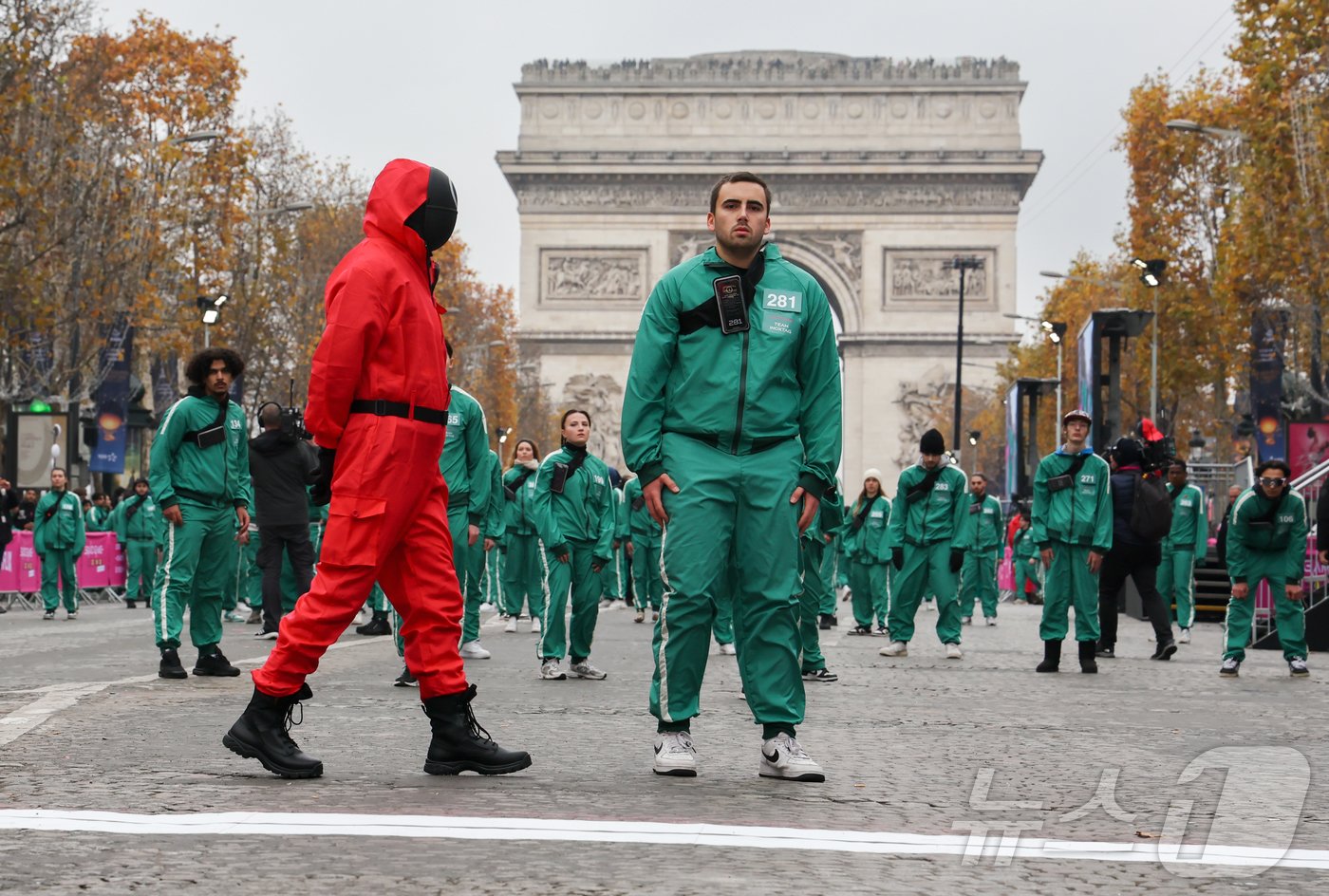 본문 이미지 - 1일(현지시간) 프랑스 파리 샹젤리제 거리에서 열린 넷플릭스 오리지널 시리즈 ‘오징어게임’ 재현 현장 이벤트에서 참가자들이 드라마 속 게임인 ‘무궁화꽃이 피었습니다’에 참여하고 있다.  2024.12.2/뉴스1 ⓒ News1 이준성 기자