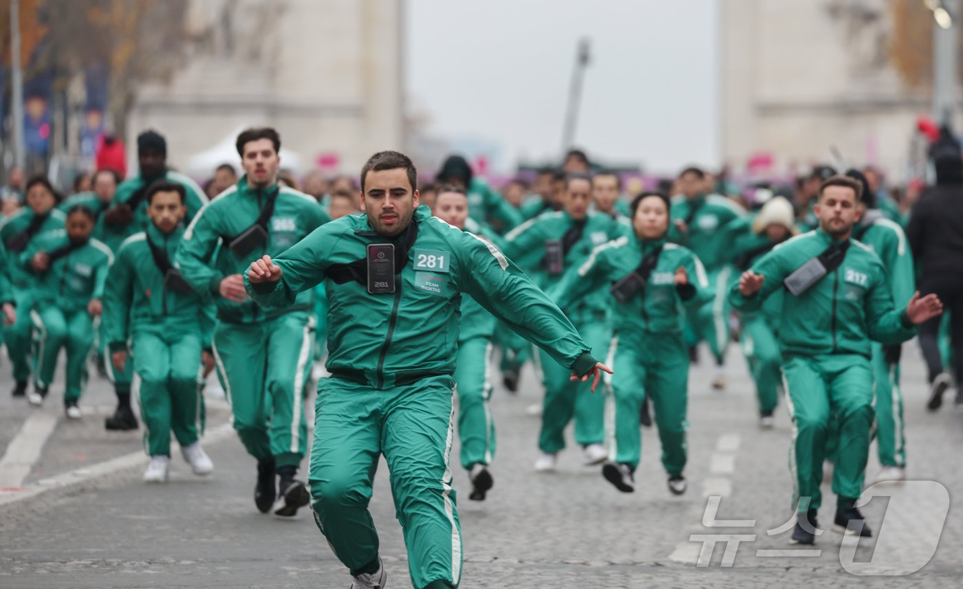 본문 이미지 - 1일(현지시간) 프랑스 파리 샹젤리제 거리에서 열린 넷플릭스 오리지널 시리즈 ‘오징어게임’ 재현 현장 이벤트에서 참가자들이 드라마 속 게임인 ‘무궁화꽃이 피었습니다’에 참여하고 있다.  2024.12.2/뉴스1 ⓒ News1 이준성 기자