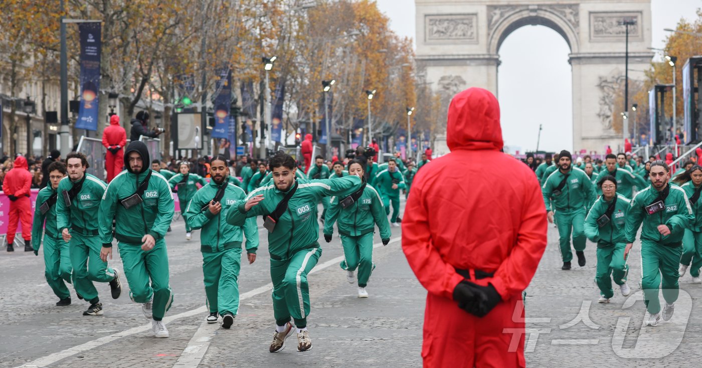 본문 이미지 - 1일(현지시간) 프랑스 파리 샹젤리제 거리에서 열린 넷플릭스 오리지널 시리즈 ‘오징어게임’ 재현 현장 이벤트에서 참가자들이 드라마 속 게임인 ‘무궁화꽃이 피었습니다’에 참여하고 있다.  2024.12.2/뉴스1 ⓒ News1 이준성 기자