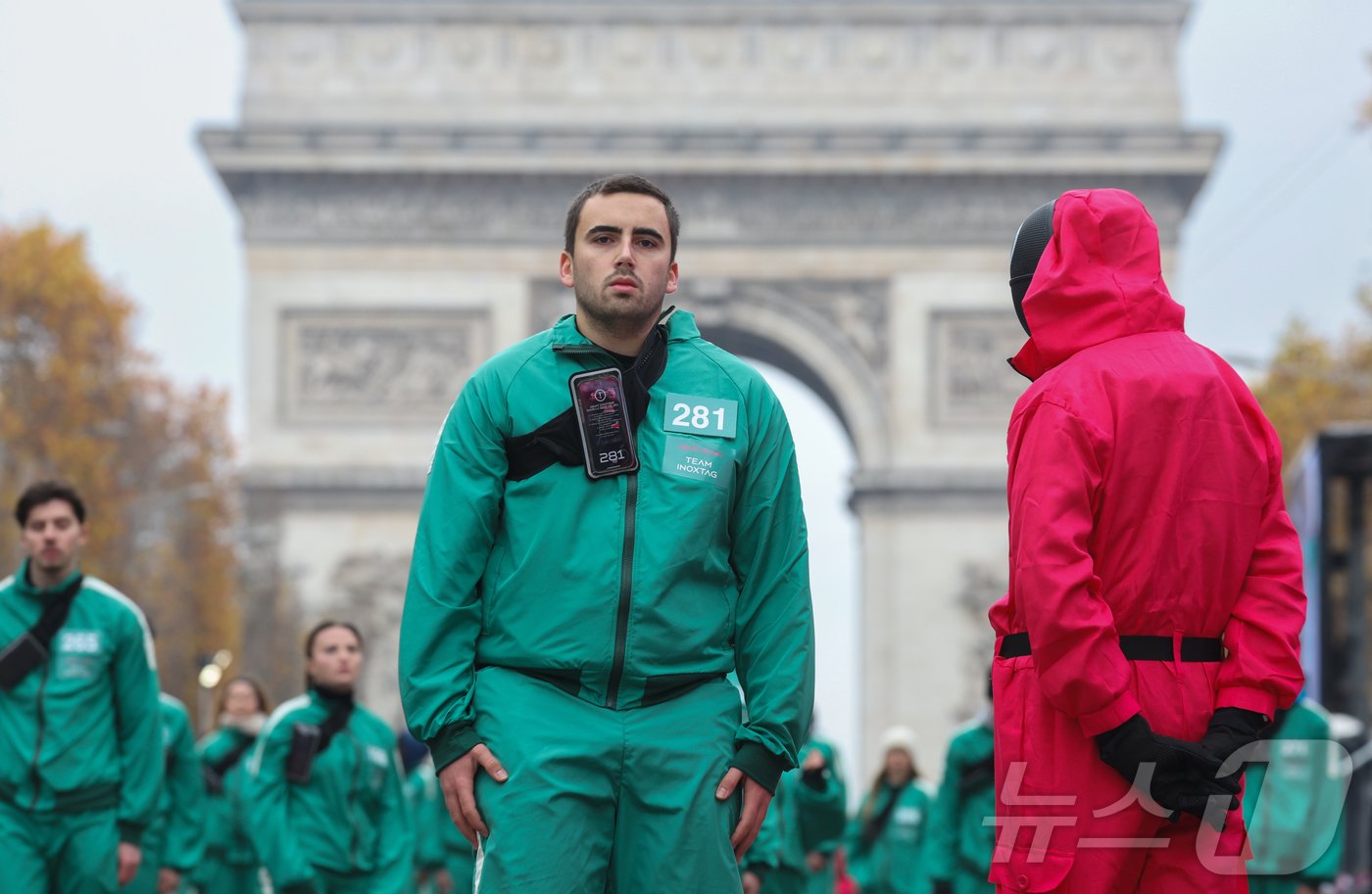 본문 이미지 - 11일(현지시간) 프랑스 파리 샹젤리제 거리에서 열린 넷플릭스 오리지널 시리즈 ‘오징어게임’ 재현 현장 이벤트에서 참가자들이 드라마 속 게임인 ‘무궁화꽃이 피었습니다’에 참여하고 있다.  2024.12.2/뉴스1 ⓒ News1 이준성 기자