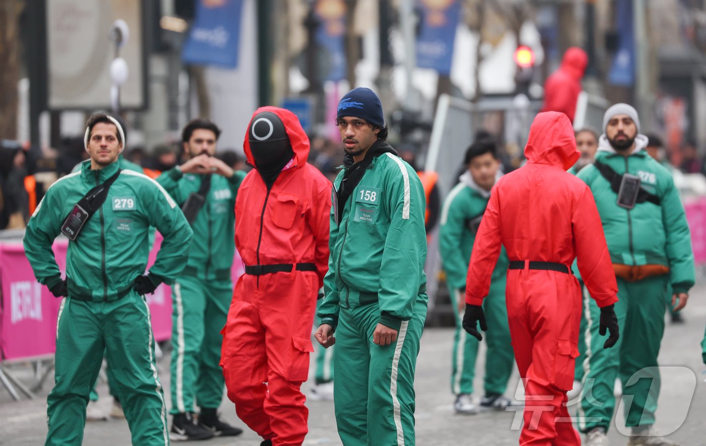 본문 이미지 - 1일(현지시간) 프랑스 파리 샹젤리제 거리에서 열린 넷플릭스 오리지널 시리즈 ‘오징어게임’ 재현 현장 이벤트에서 참가자들이 드라마 속 게임인 ‘무궁화꽃이 피었습니다’에 참여하고 있다.  2024.12.2/뉴스1 ⓒ News1 이준성 기자