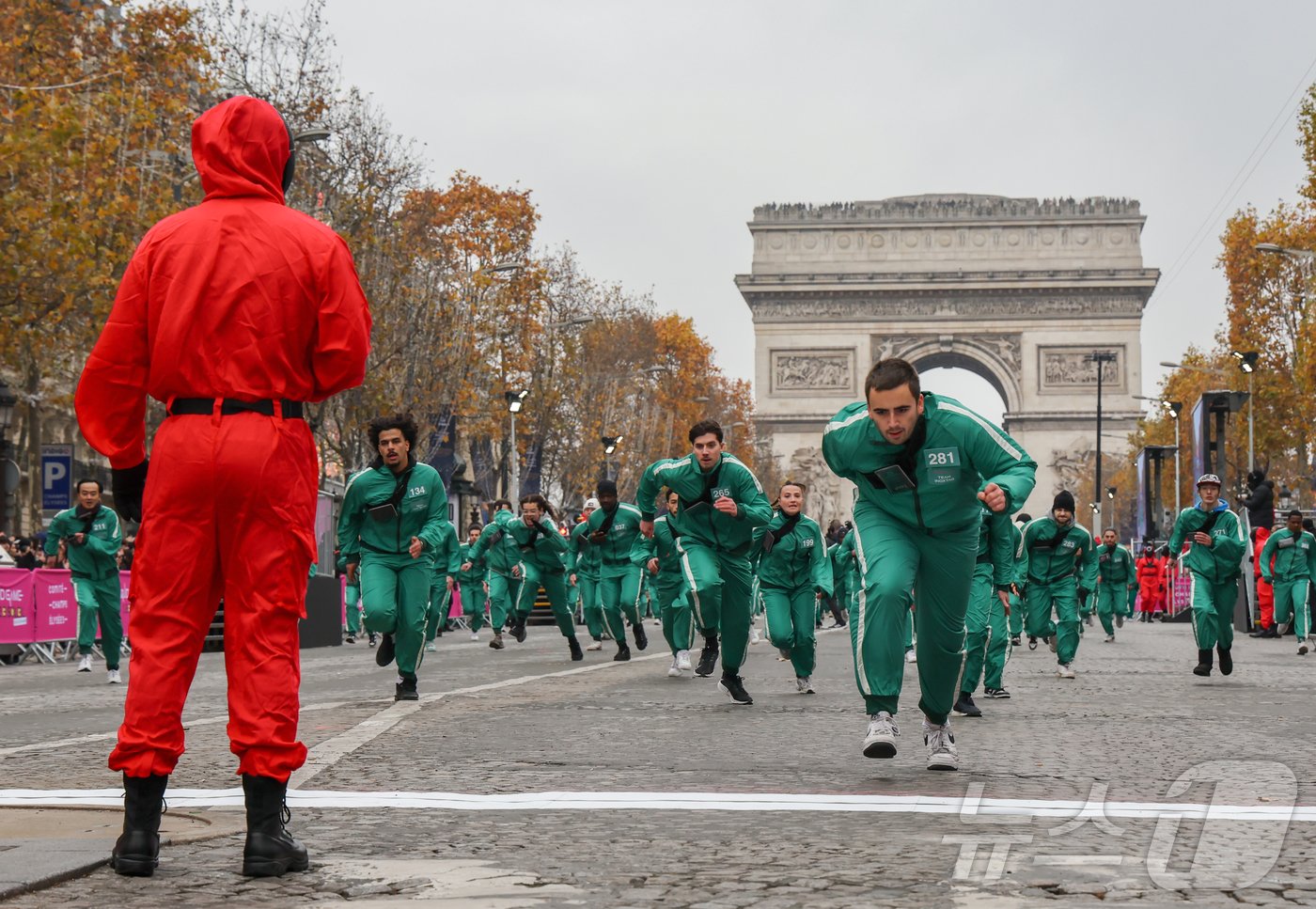 본문 이미지 - 11일(현지시간) 프랑스 파리 샹젤리제 거리에서 열린 넷플릭스 오리지널 시리즈 ‘오징어게임’ 재현 현장 이벤트에서 참가자들이 드라마 속 게임인 ‘무궁화꽃이 피었습니다’에 참여하고 있다.  2024.12.2/뉴스1 ⓒ News1 이준성 기자